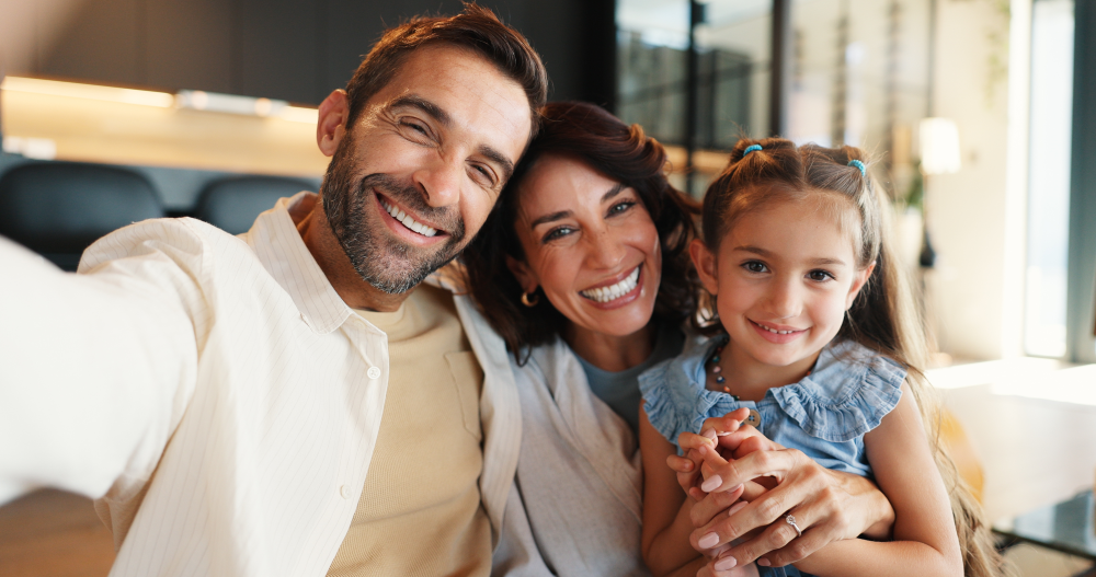 Parents and their daughter smiling together at home
