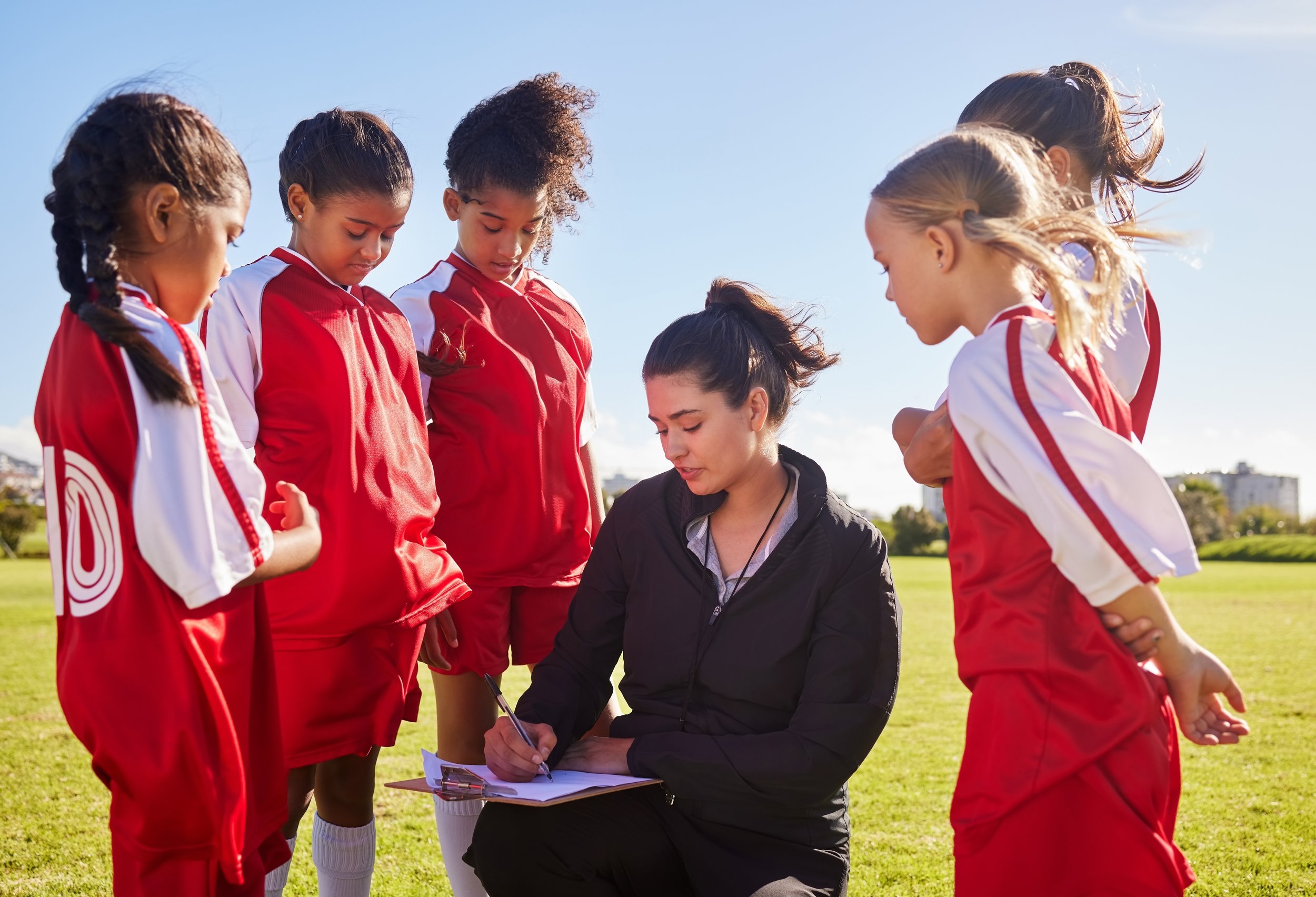Coach speaking with young soccer players