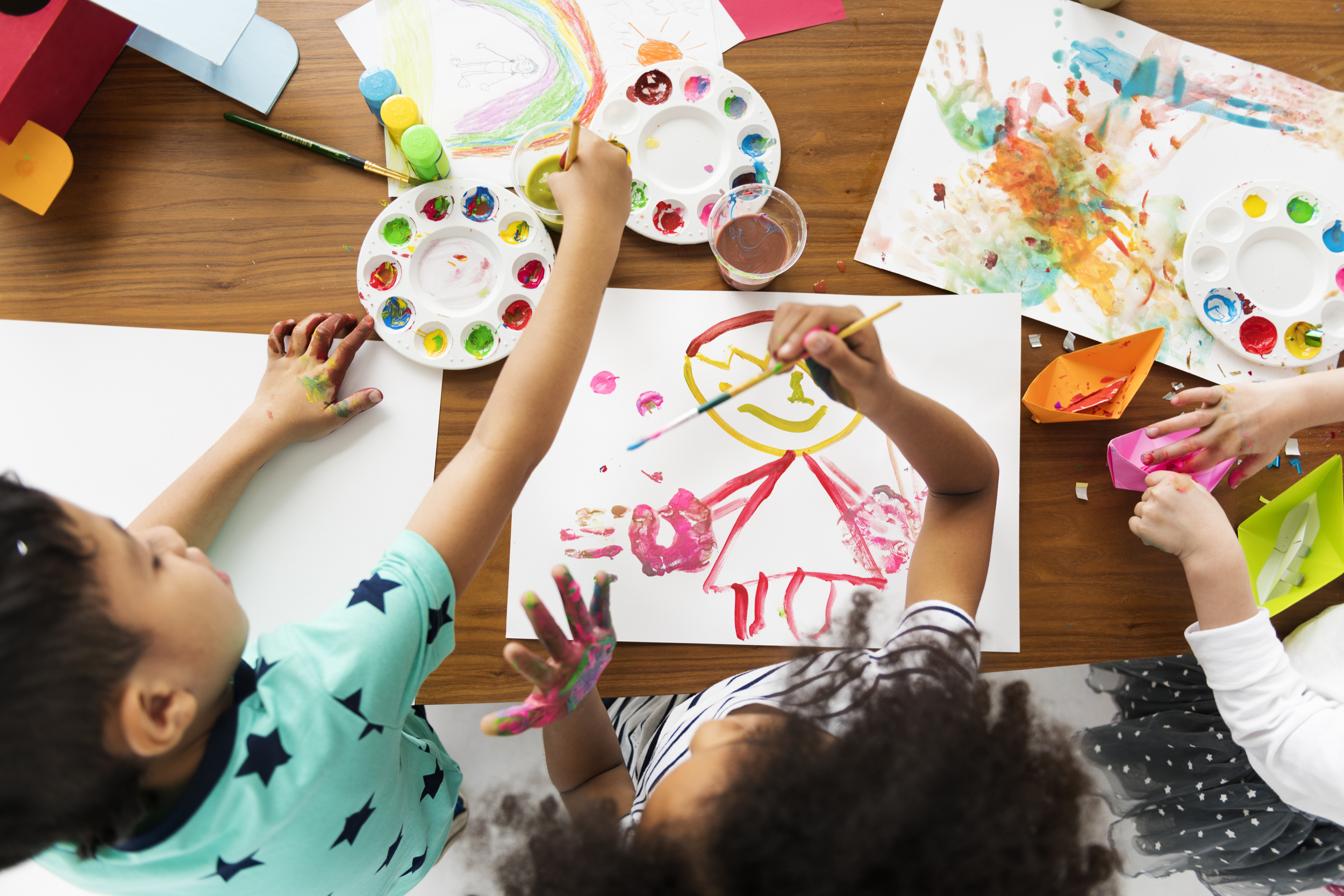 Children painting together during a community arts activity