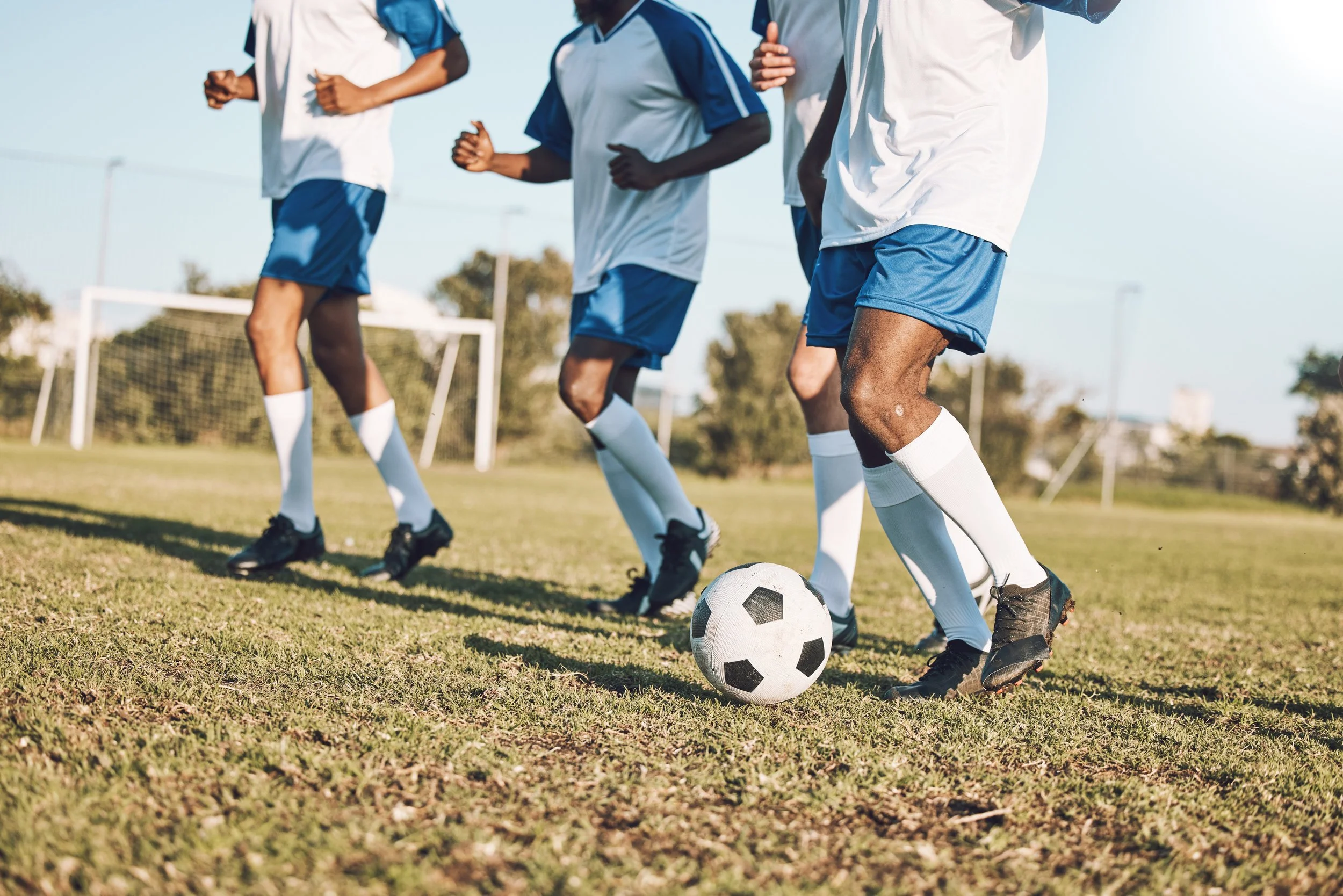 Young people playing soccer on a field