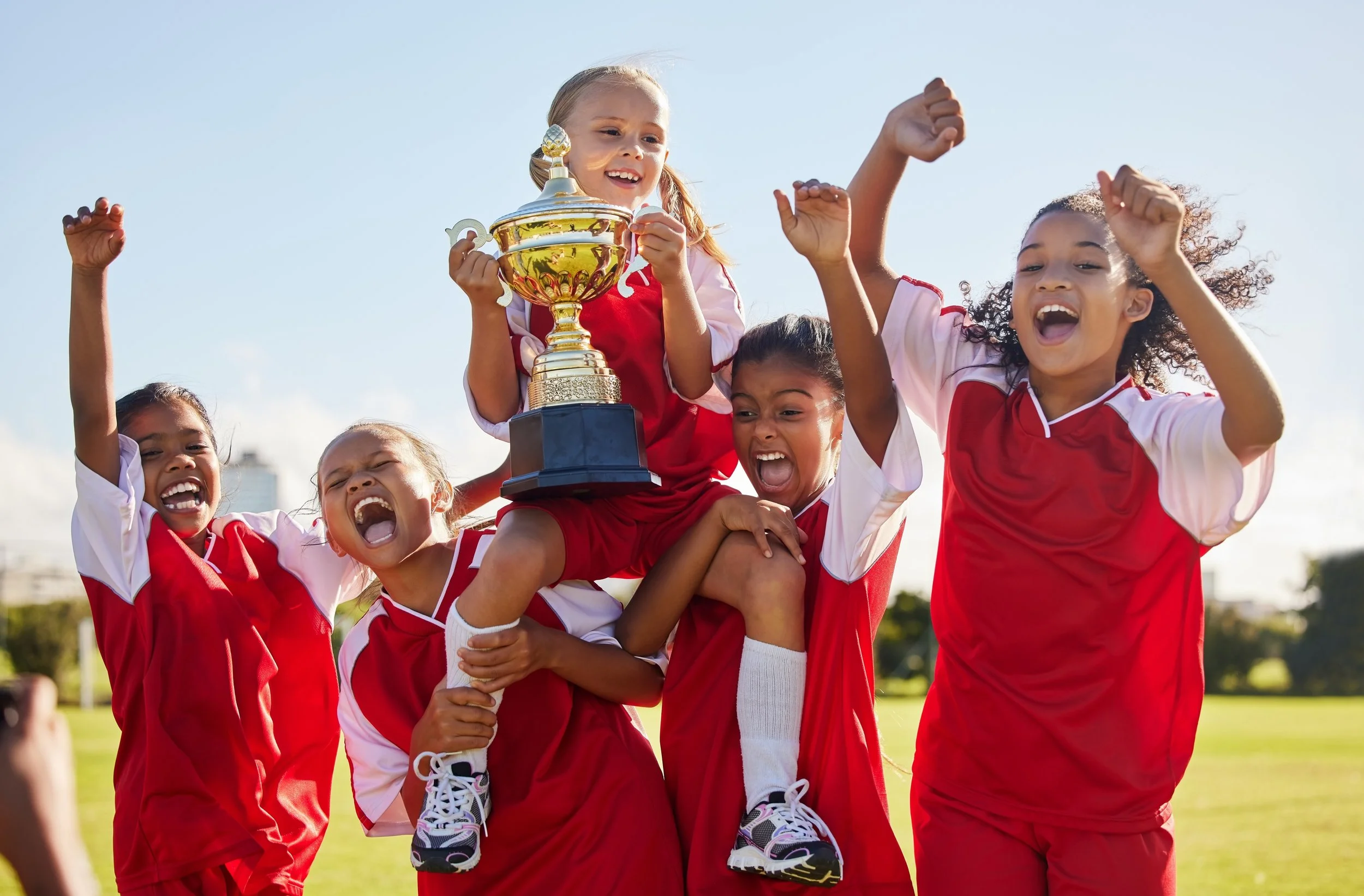 Youth soccer team celebrating with a trophy