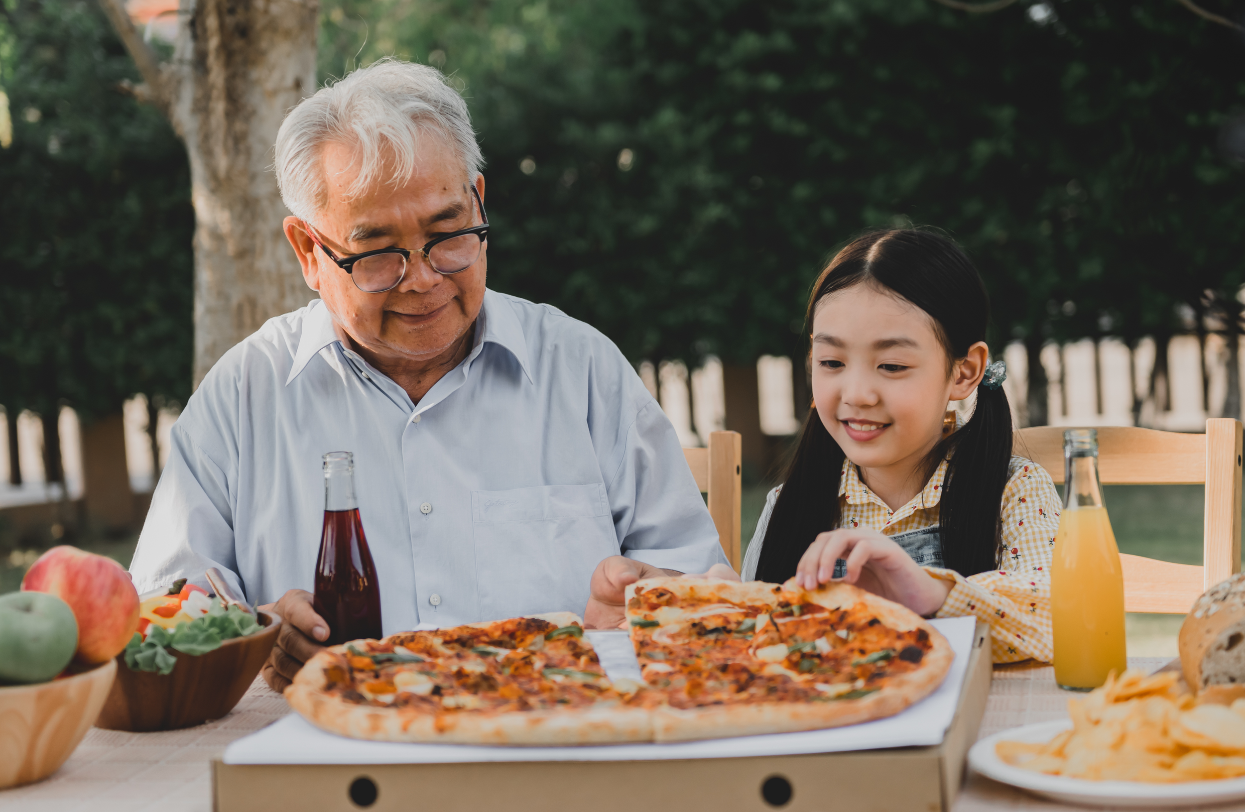 Grandfather and granddaughter sharing pizza