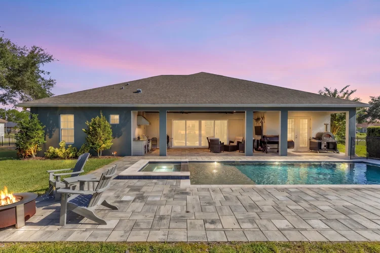 Twilight view of a pool and patio area