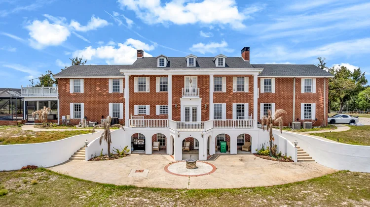 Rear patio exterior of a brick colonial-style home