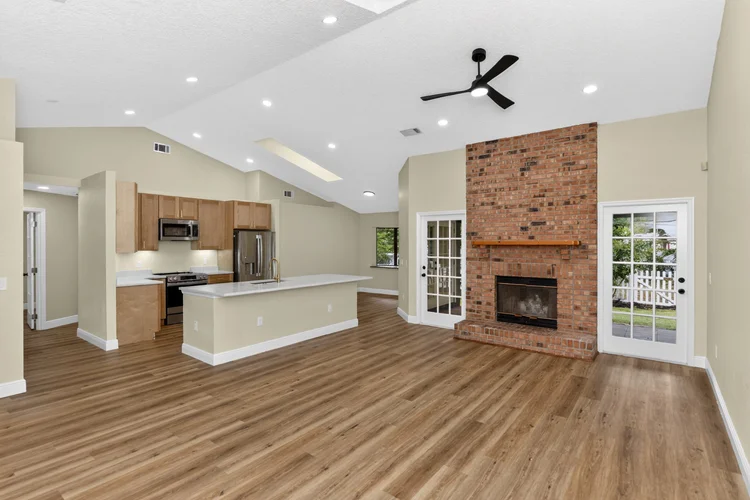 Open-concept kitchen and living room with brick fireplace