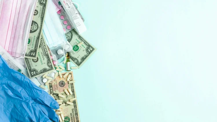Dollar bills with a surgical mask, gloves and medicines