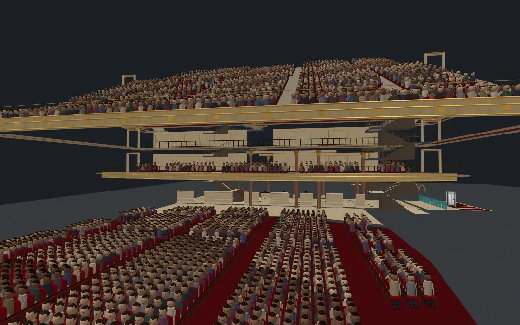 Elevated front-right stage view toward Wang Theatre’s modeled main-floor audience, upper seating tiers, walkways and stairs; the nearest foreground rows extend beyond the frame.