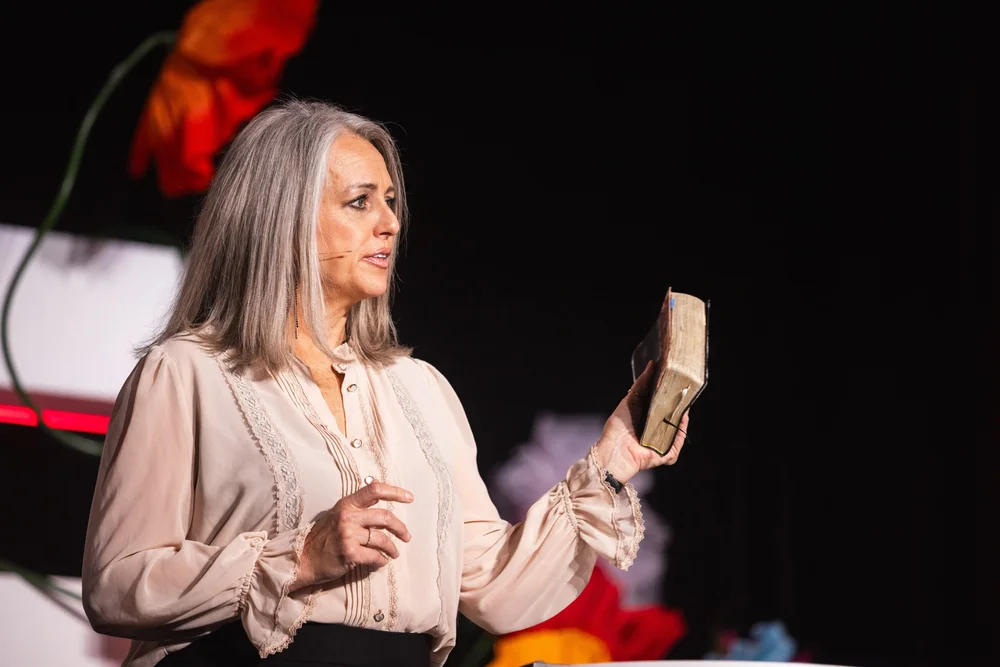 A speaker holding a Bible on the MORE stage