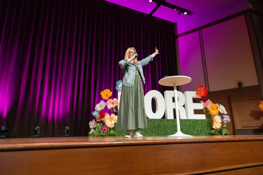 A speaker addressing the MORE 2025 audience on stage