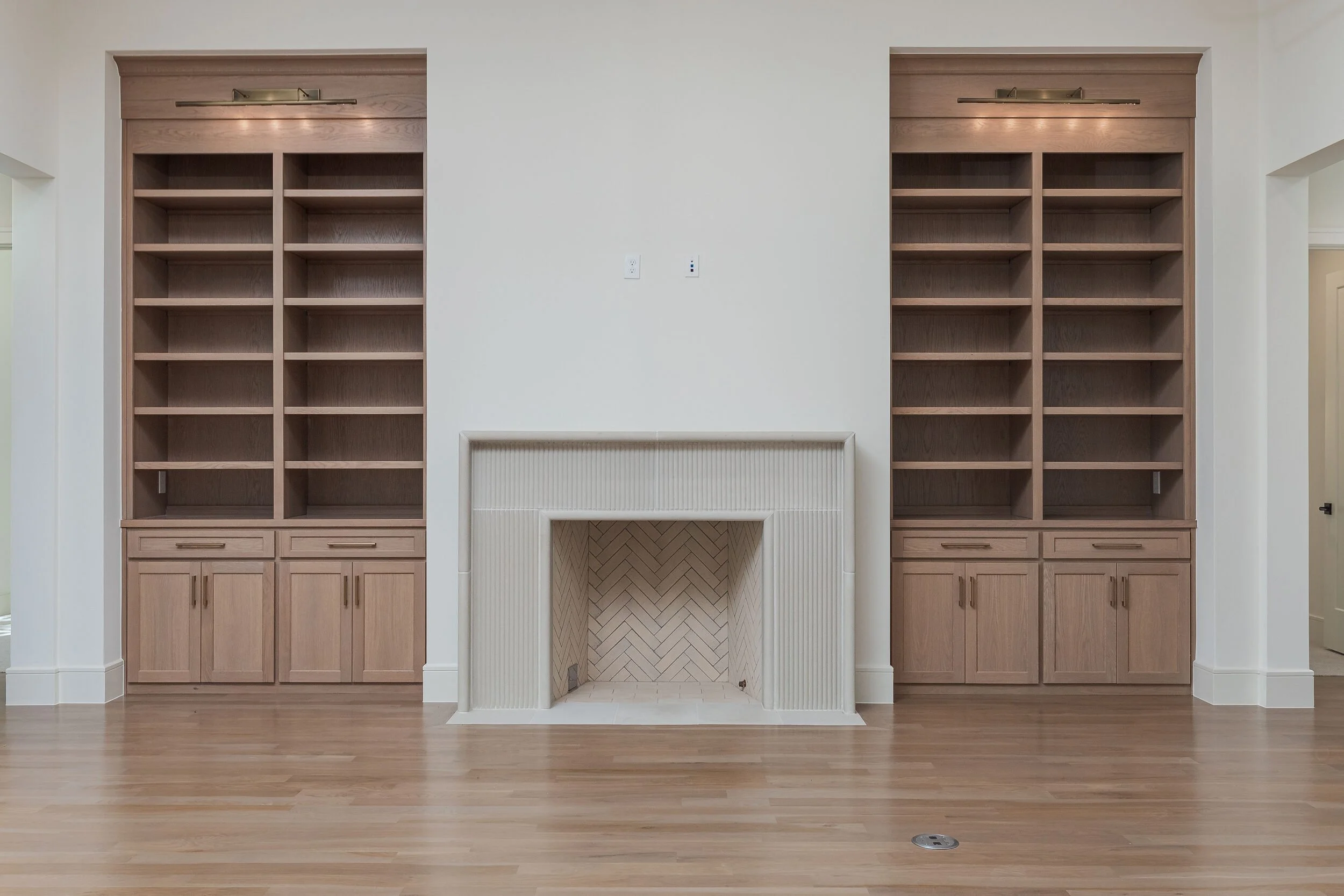 Great room fireplace flanked by white oak built-in shelving