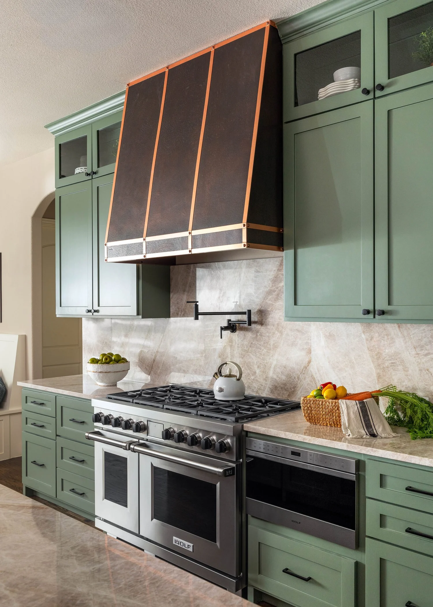 Range wall with green cabinetry, quartzite backsplash and a professional range