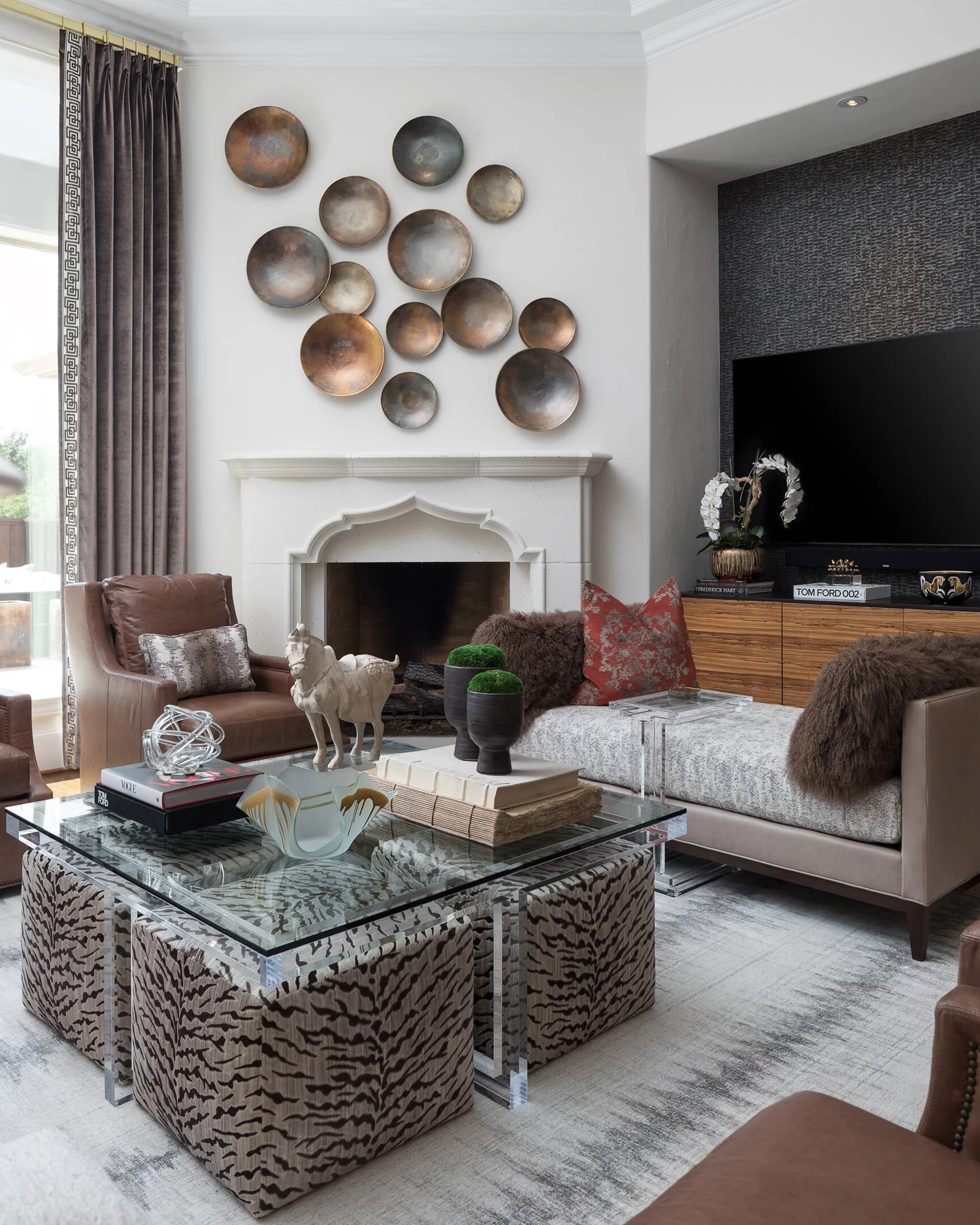 Seating group around a glass coffee table with the fireplace wall behind