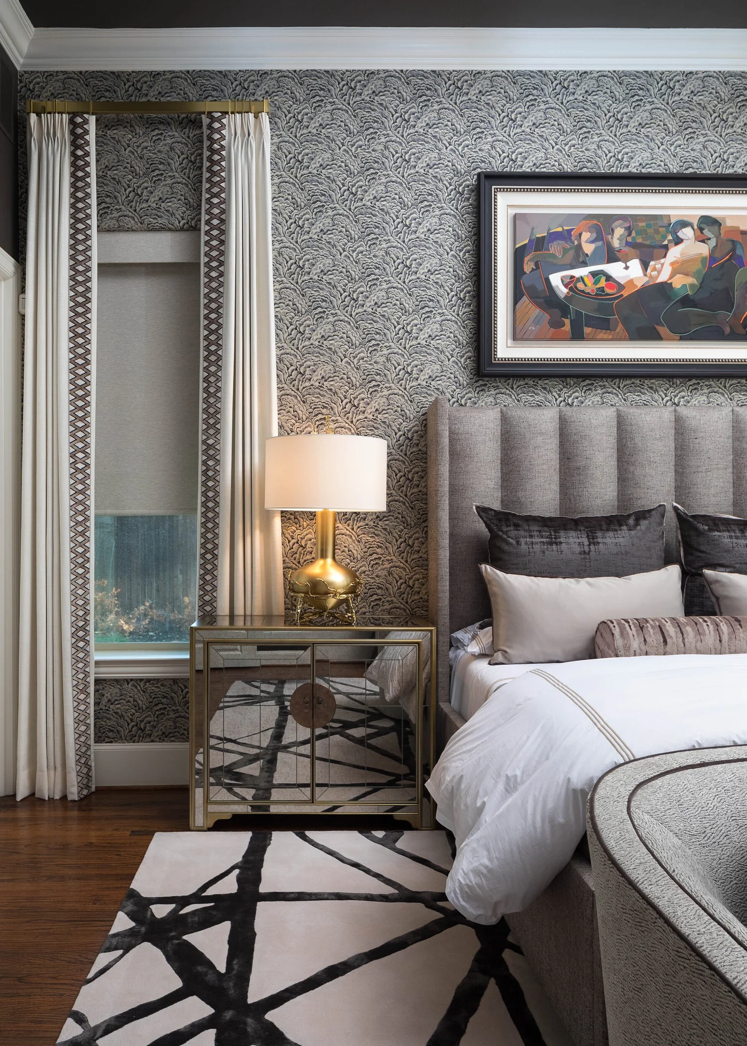 Side view of the bed with brass lamp, mirrored nightstand and graphic rug
