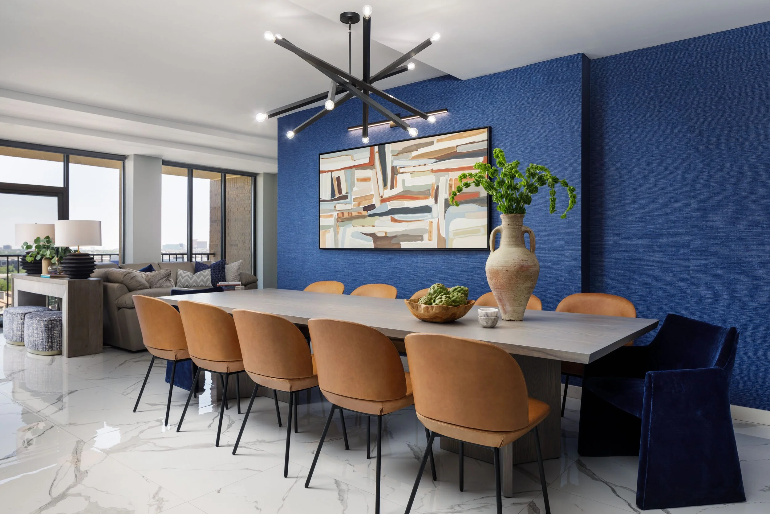 Dining room seen toward the windows, with the living area and city view beyond