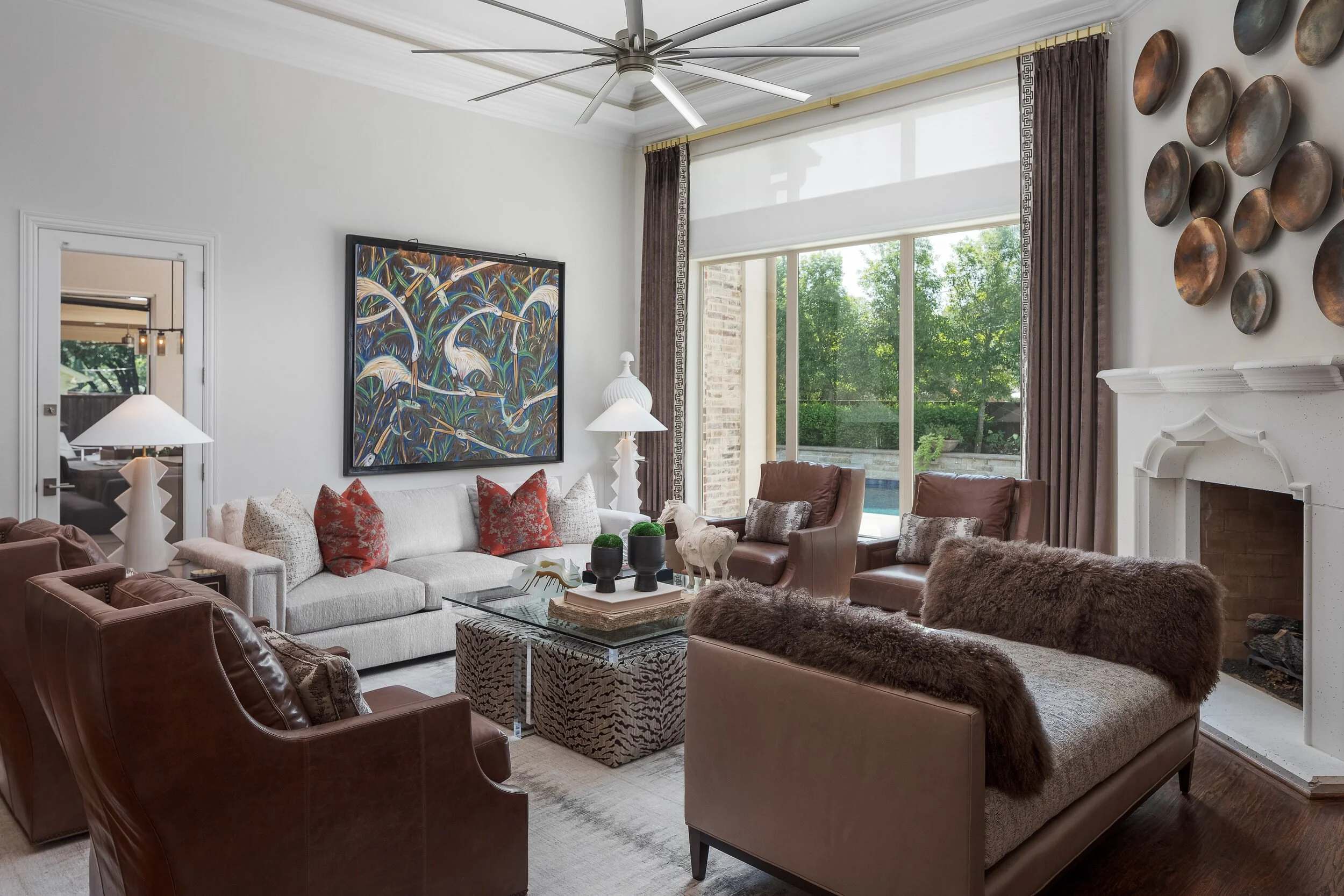 Wide view of the living room with a heron artwork, fireplace and garden windows
