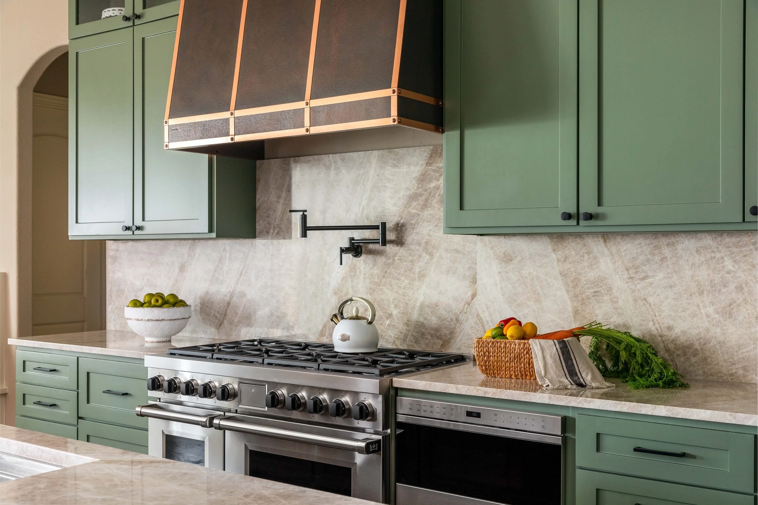 Range wall with a pot filler, quartzite slab backsplash and sage green cabinetry