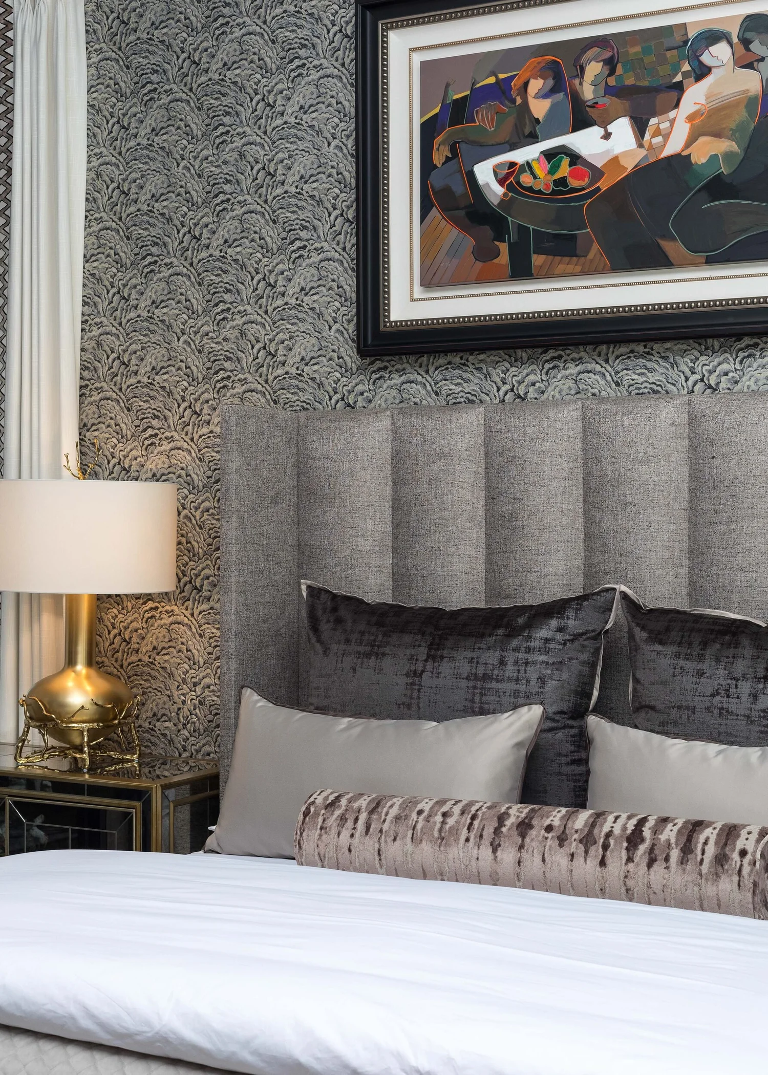 Detail of layered velvet pillows against a channel-tufted headboard