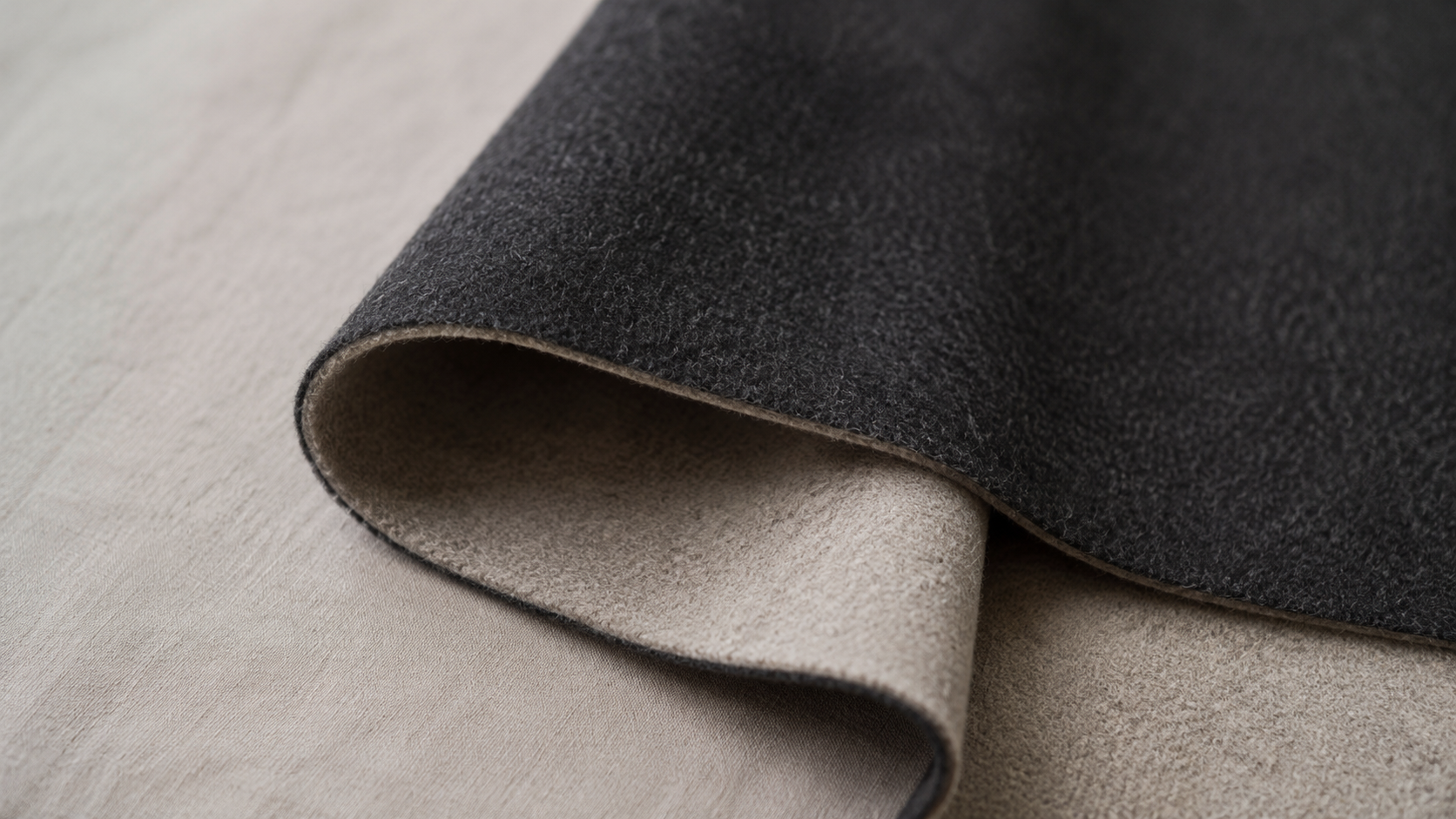 Close-up of a heavy double-face wool coating showing its two-layer construction and visible weight