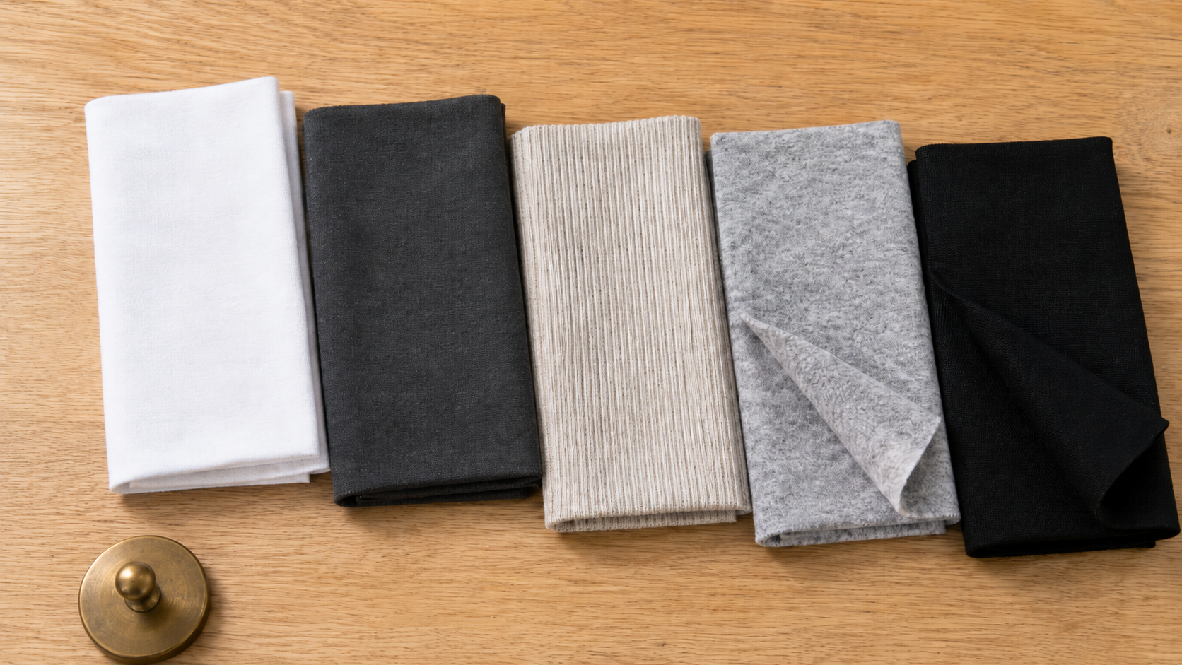 Knit fabric swatches showing different constructions including jersey, interlock, fleece, and pique arranged on a table