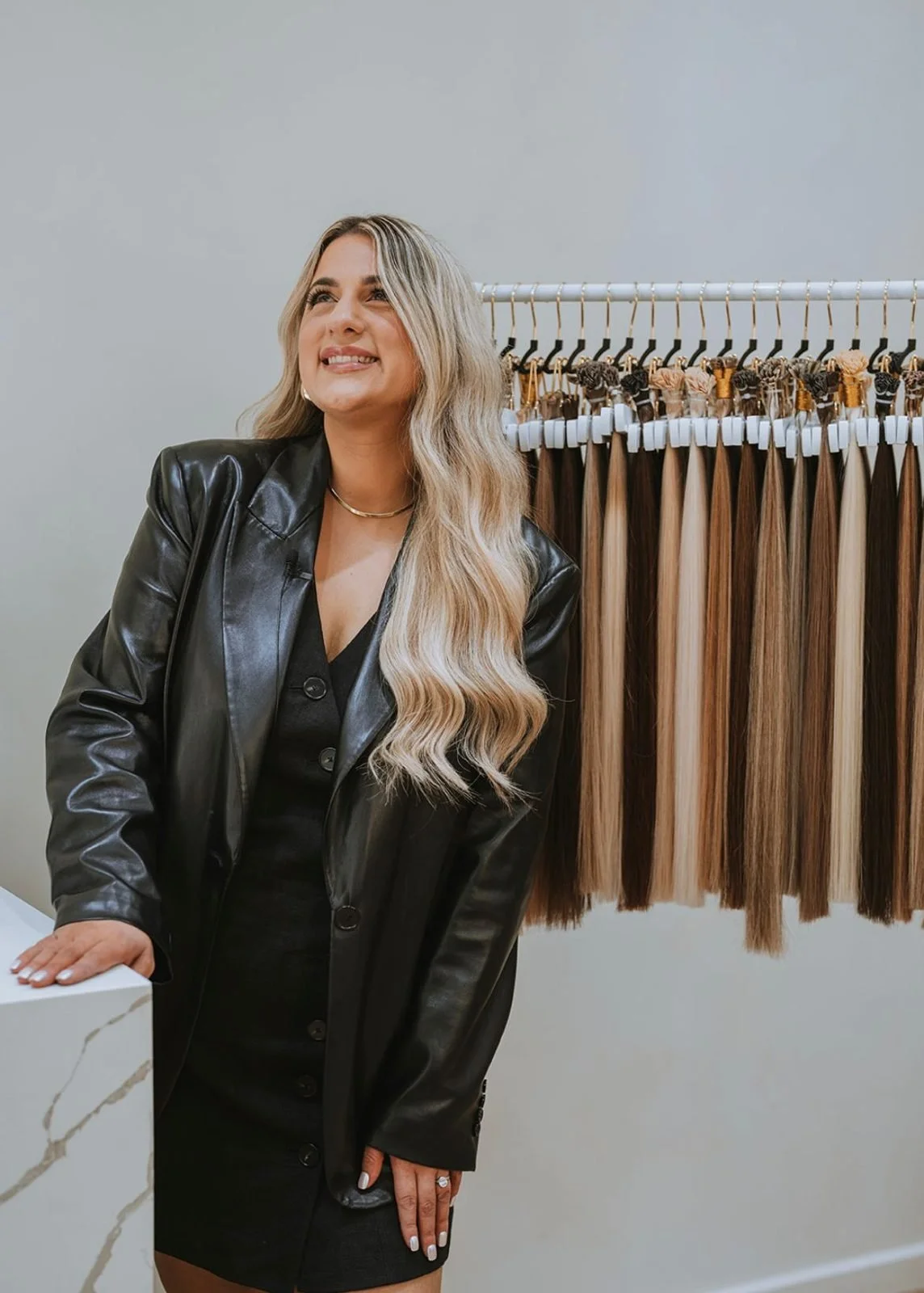 Maree Alexis in her salon beside a rail of keratin bond hair