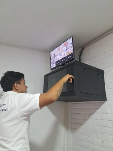 Técnico junto a un gabinete de pared y un monitor en Aroma de Mañana.
