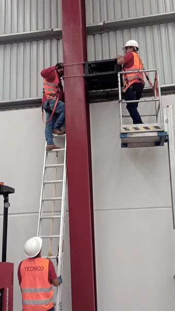 Técnicos colocando equipo en altura sobre un muro de CEDIS Sanctorum.