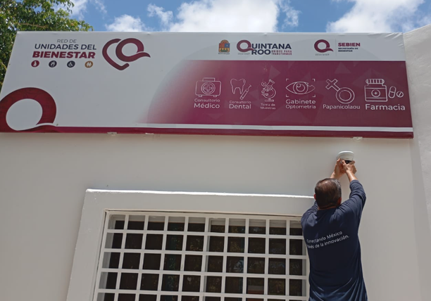 Técnico trabajando bajo el letrero de una Unidad del Bienestar en Quintana Roo.