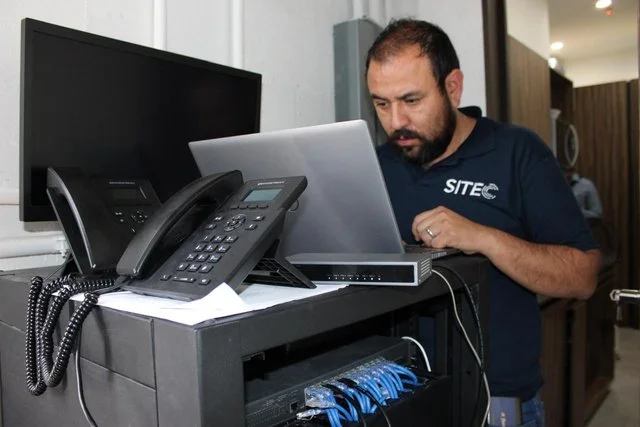 Personal de SITEC trabajando con equipos de red y telefonía en JDC Contadores.