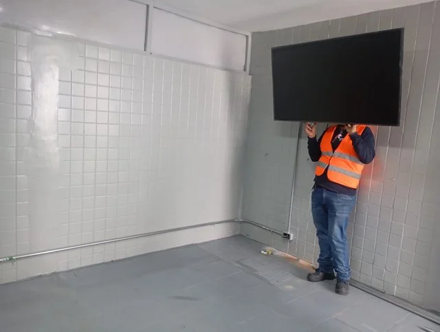 Técnico trabajando junto a una pantalla de pared en Conalum.