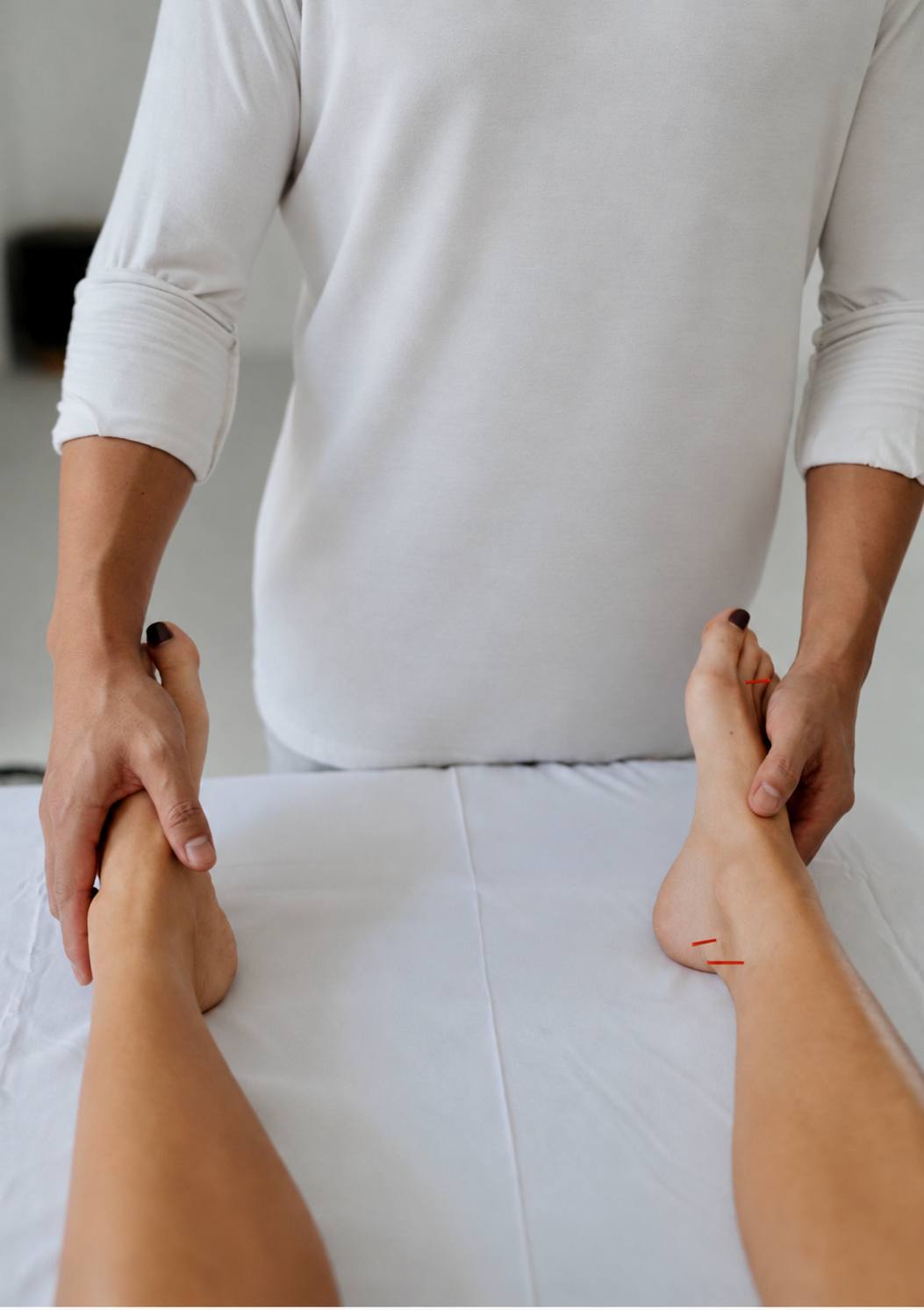 Dr. Phil supporting a patient’s feet during individualized acupuncture care