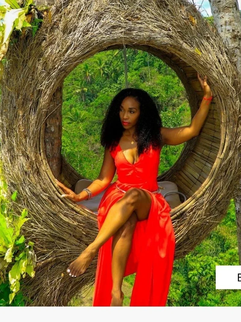 Woman in red dress at the iconic Bali nest swing surrounded by jungle