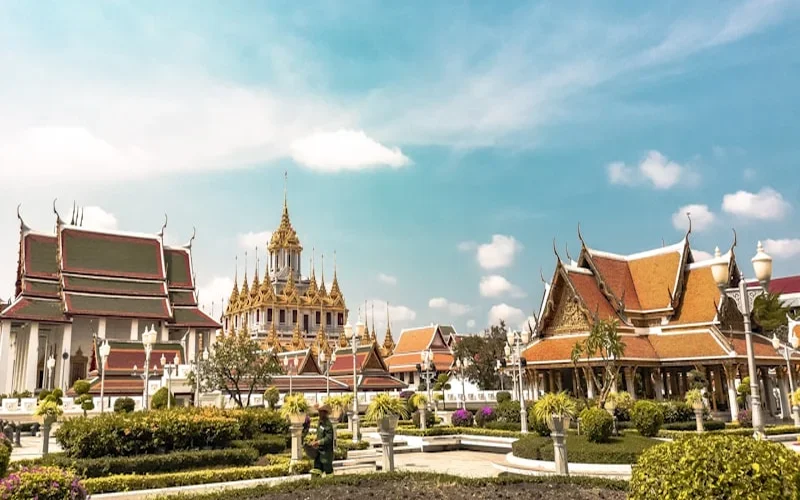 Thai temple and longtail boats in crystal-clear water