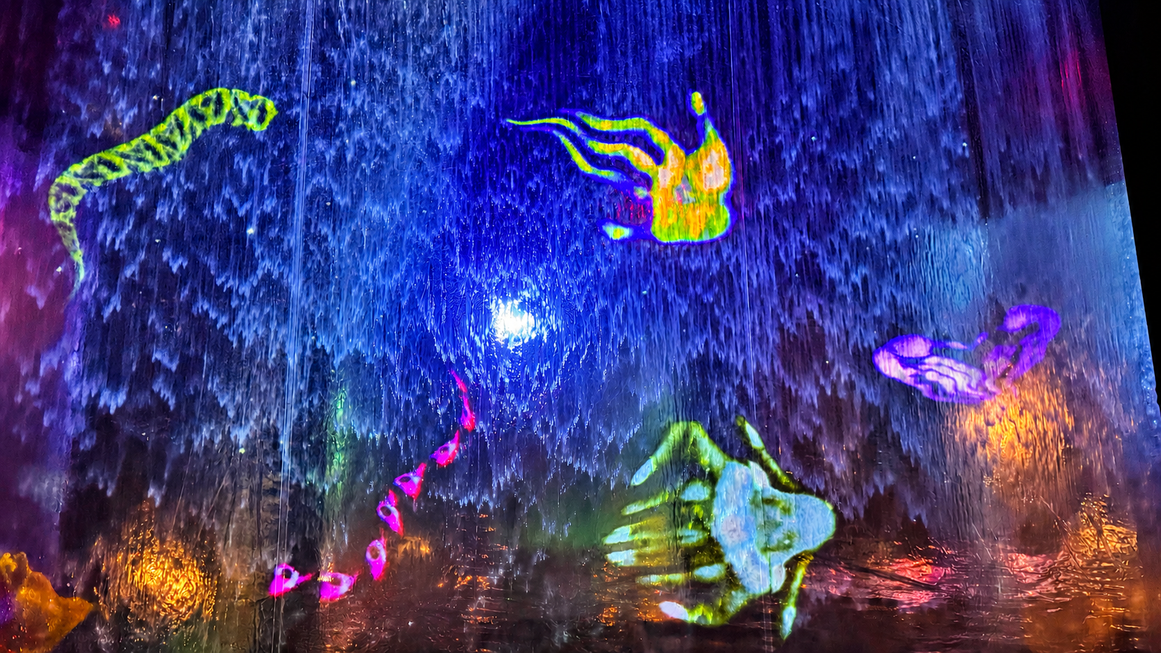 Watercolour Interactive — colourful scanned objects projected onto a flowing water curtain
