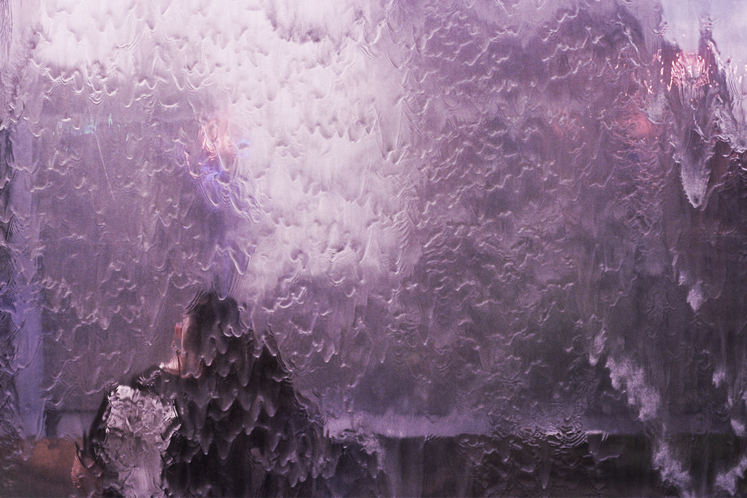 A visitor silhouetted behind the illuminated Watergate cascade in 2024