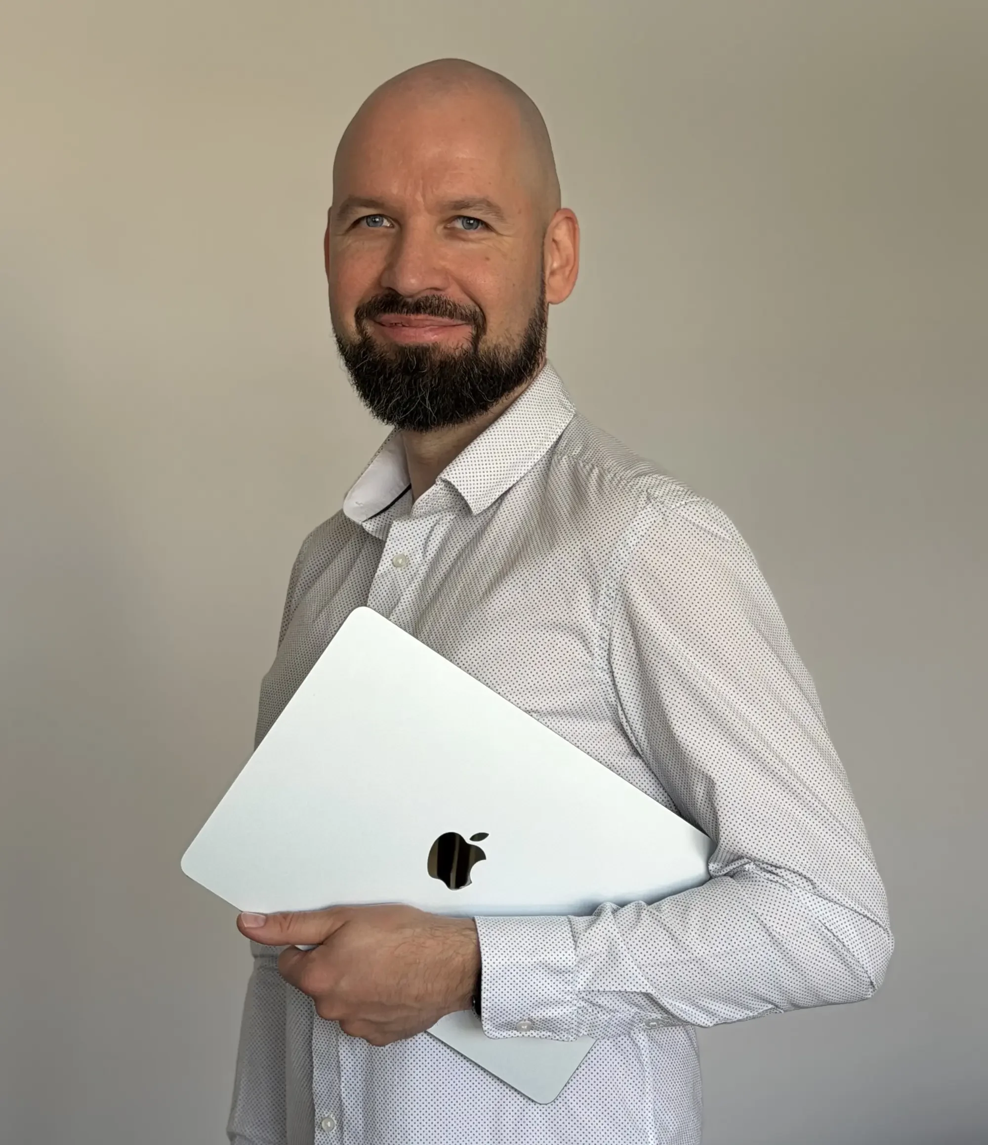 Gediminas UOGAweb Squarespace designer and SEO strategist is holding Apple MacBook and smiling