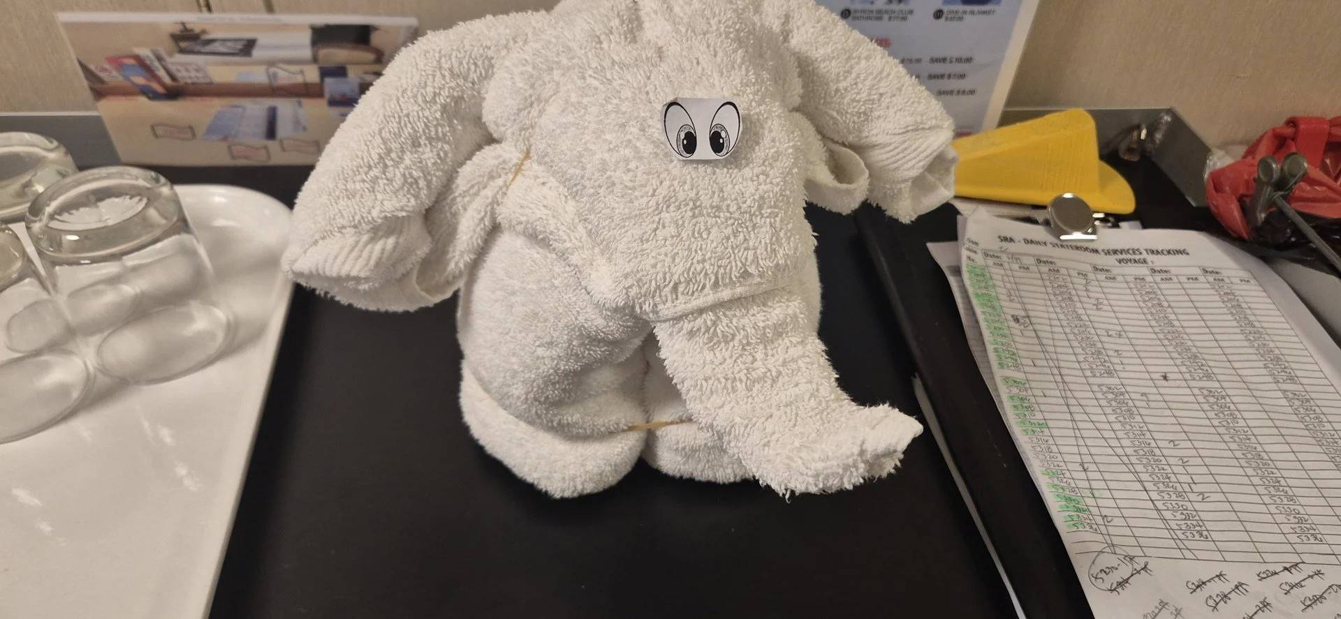 A folded towel animal on a cabin bed.