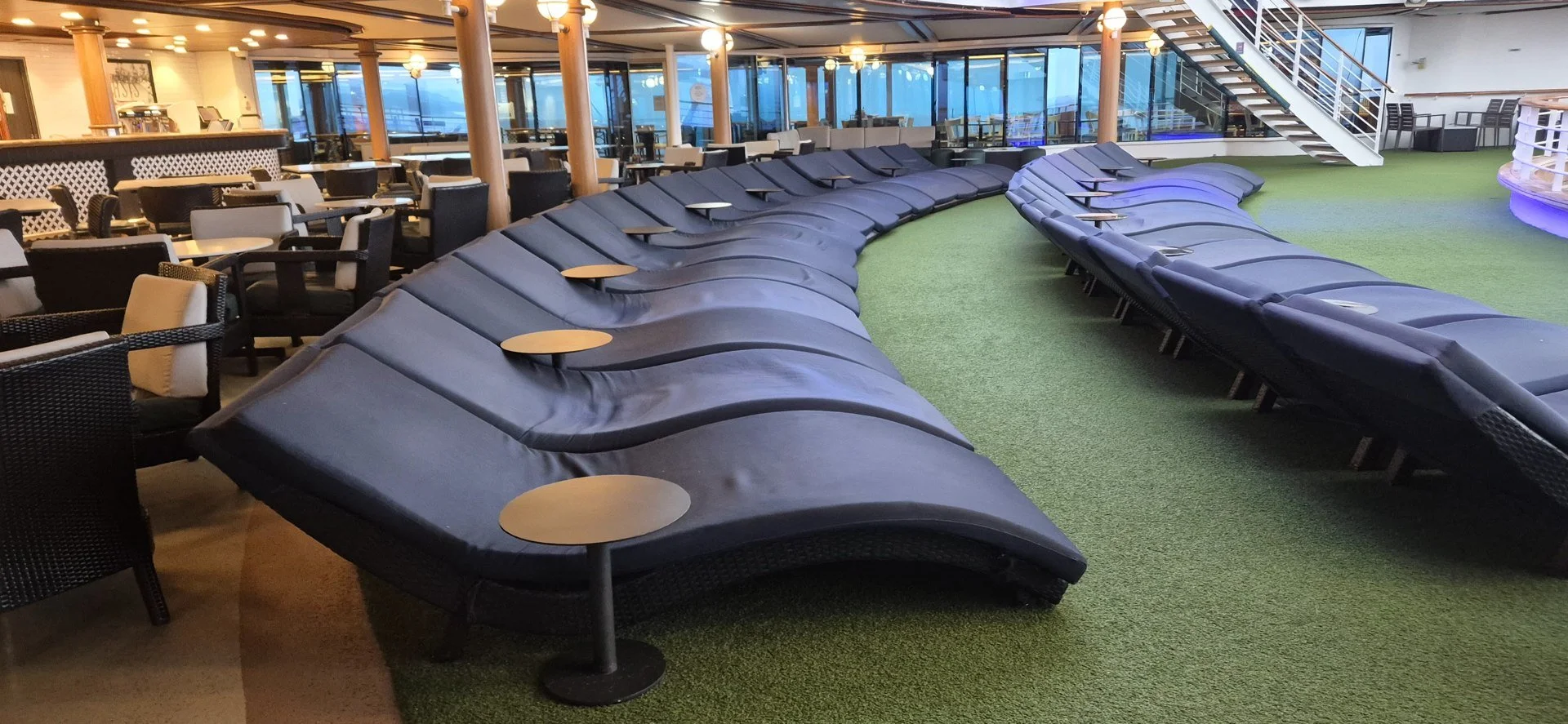 Curved row of loungers on a cruise ship deck.