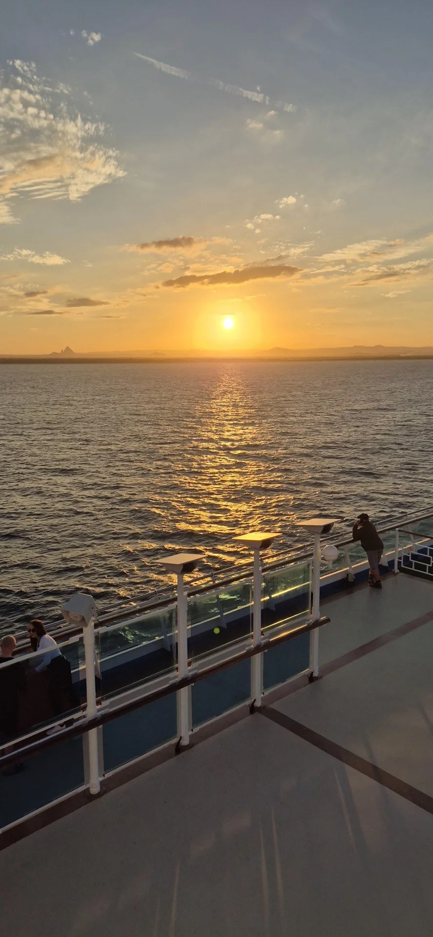 Sunset over the ocean viewed from a cruise ship deck.
