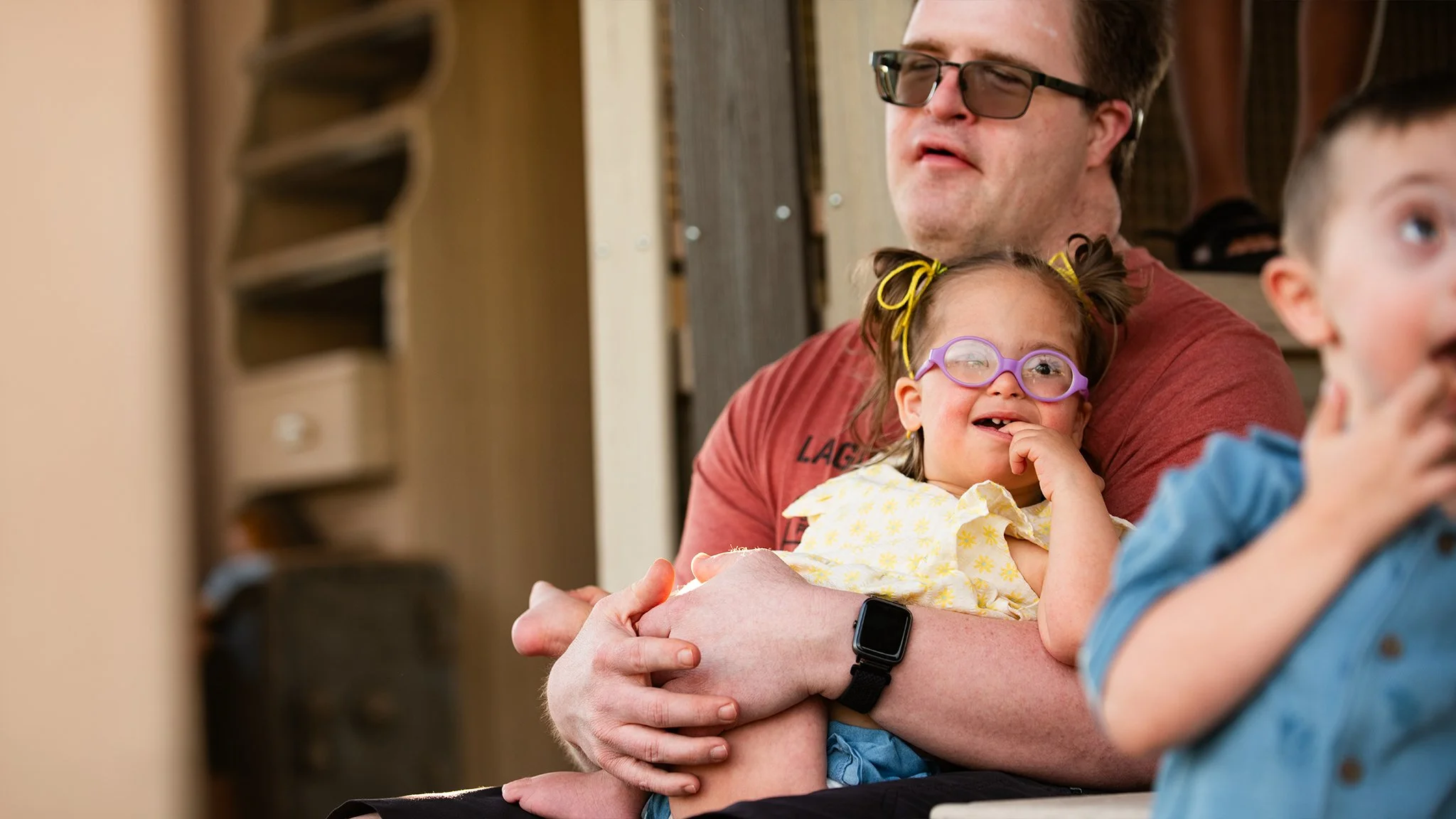 A child with Down syndrome laughing with family