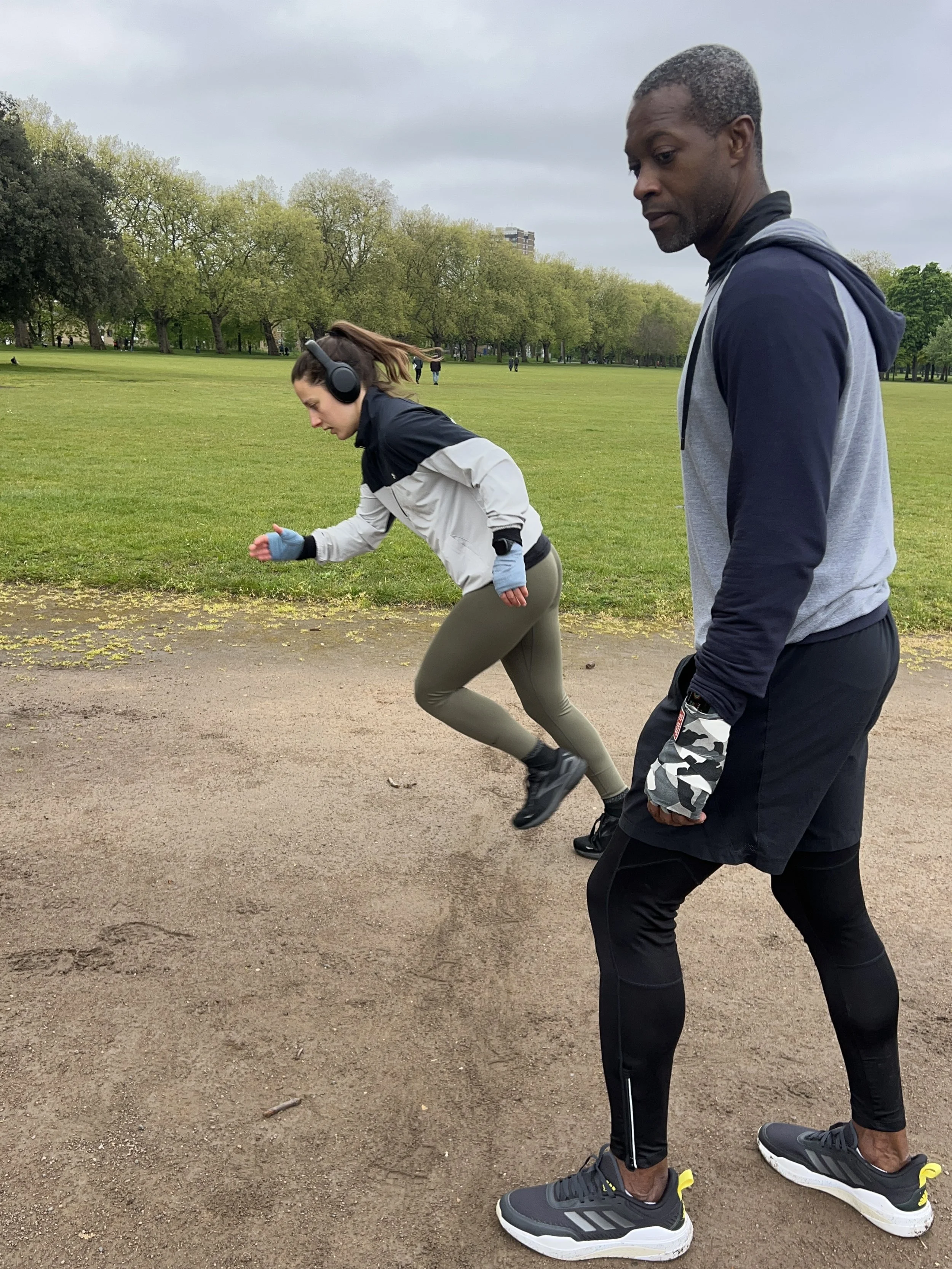 Coach supervising a participant during structured outdoor boxing drills
