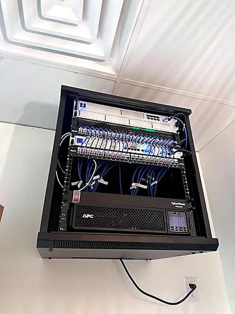 Wall-mount network rack with UniFi switching and UPS in a medical office