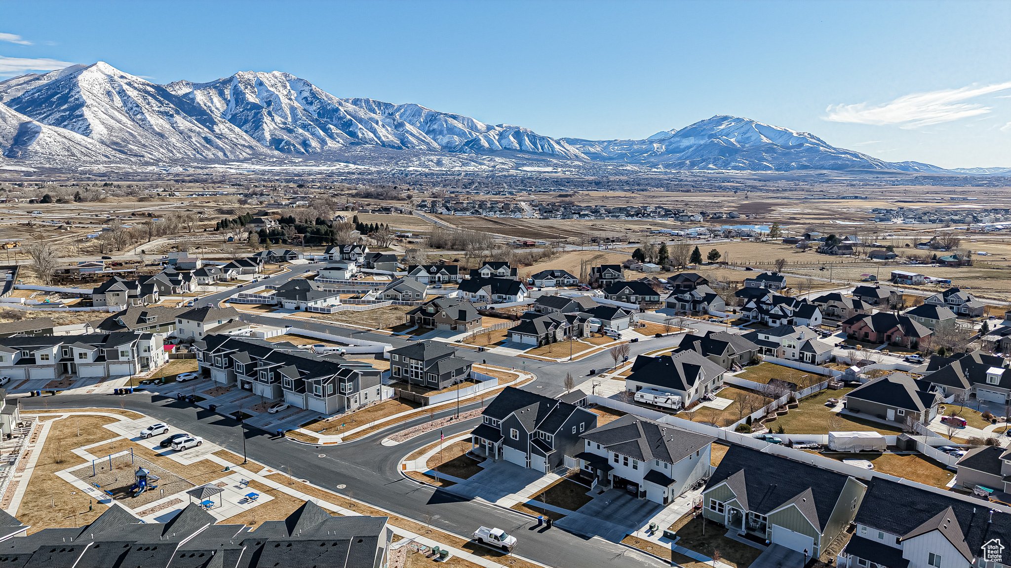 Aerial view of a Spanish Fork neighborhood beneath snow covered mountains