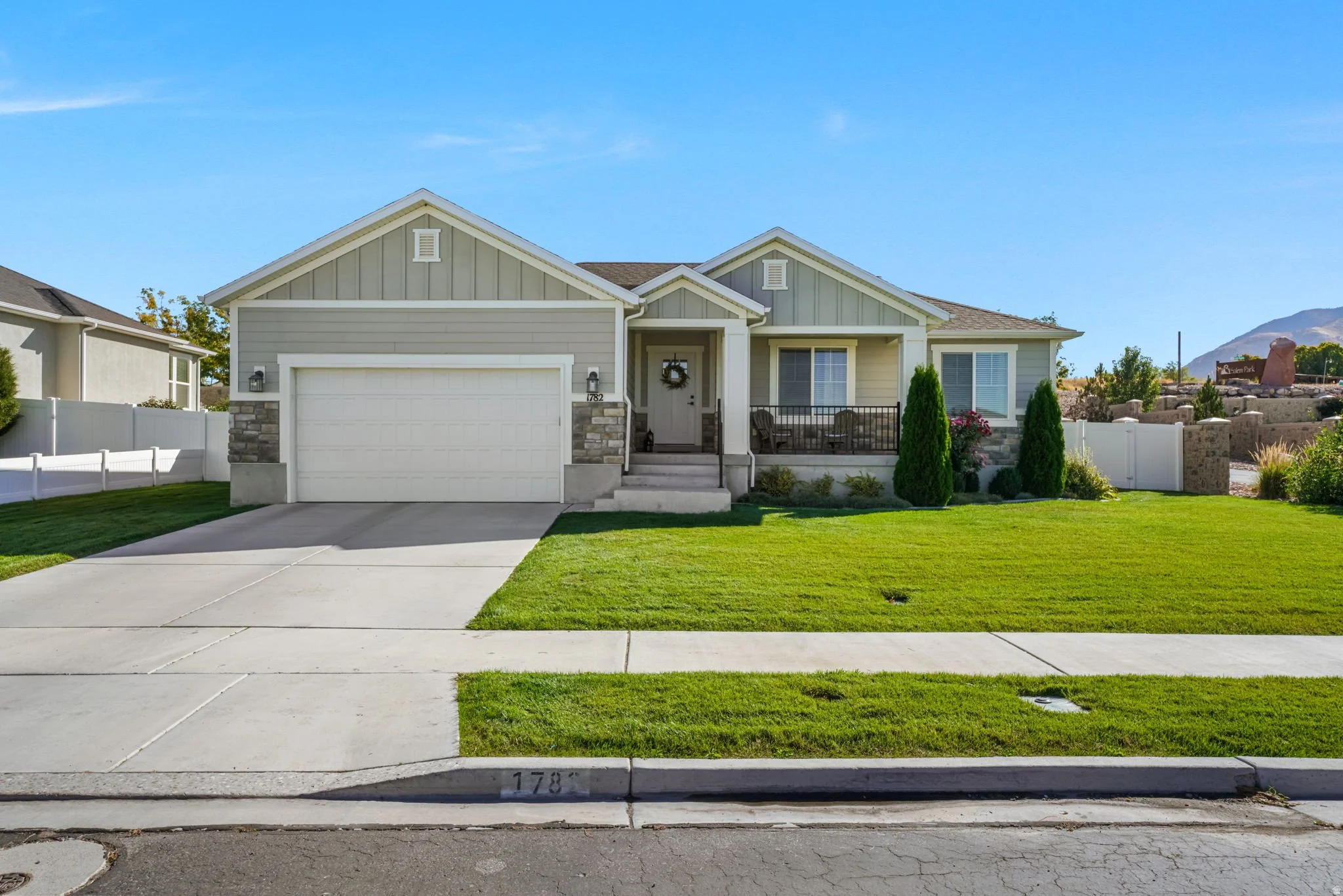 Welcoming single level Utah home with a front porch, landscaped yard, and mountain views