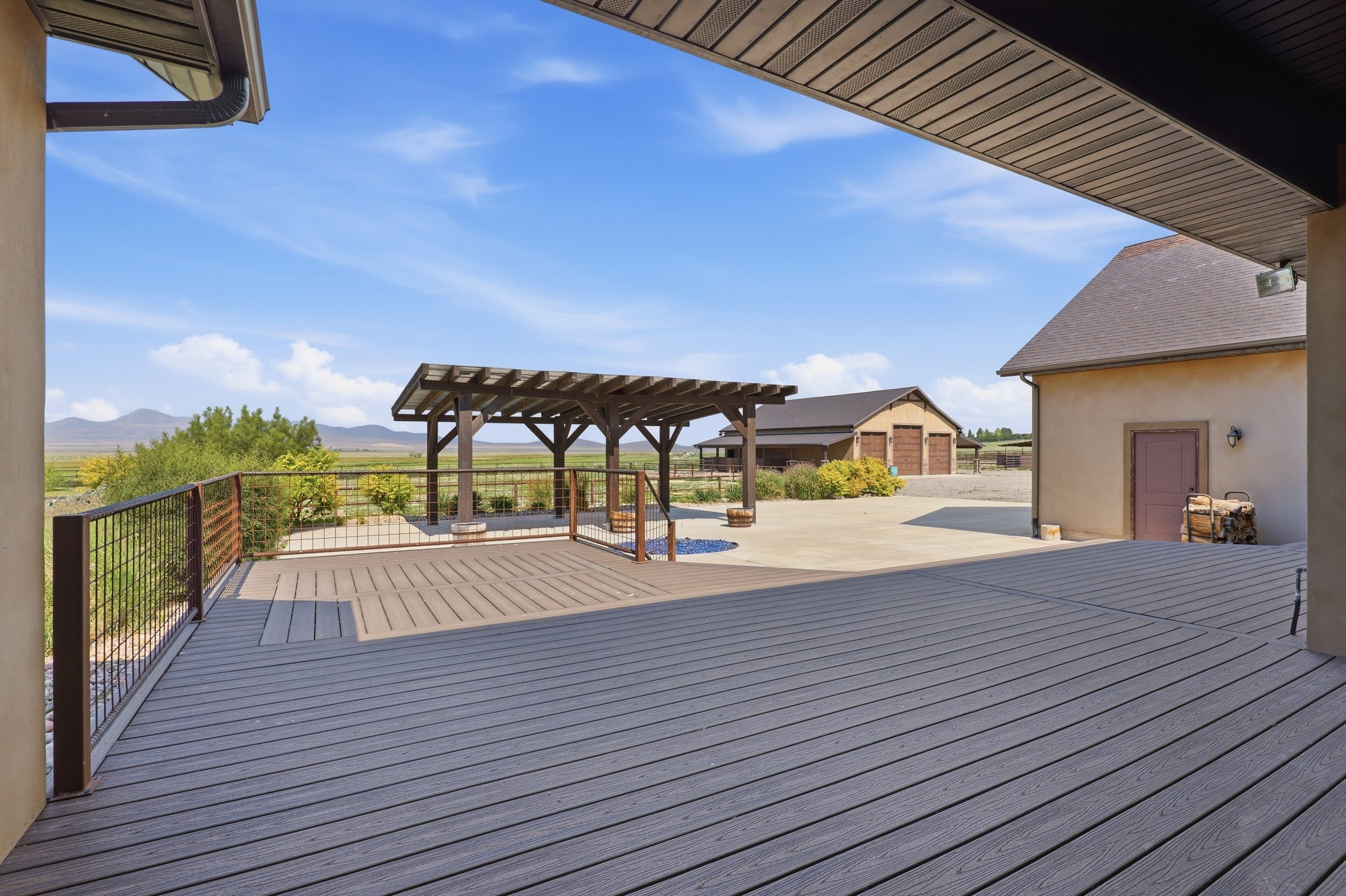 Covered outdoor living area overlooking acreage and outbuildings in Genola Utah