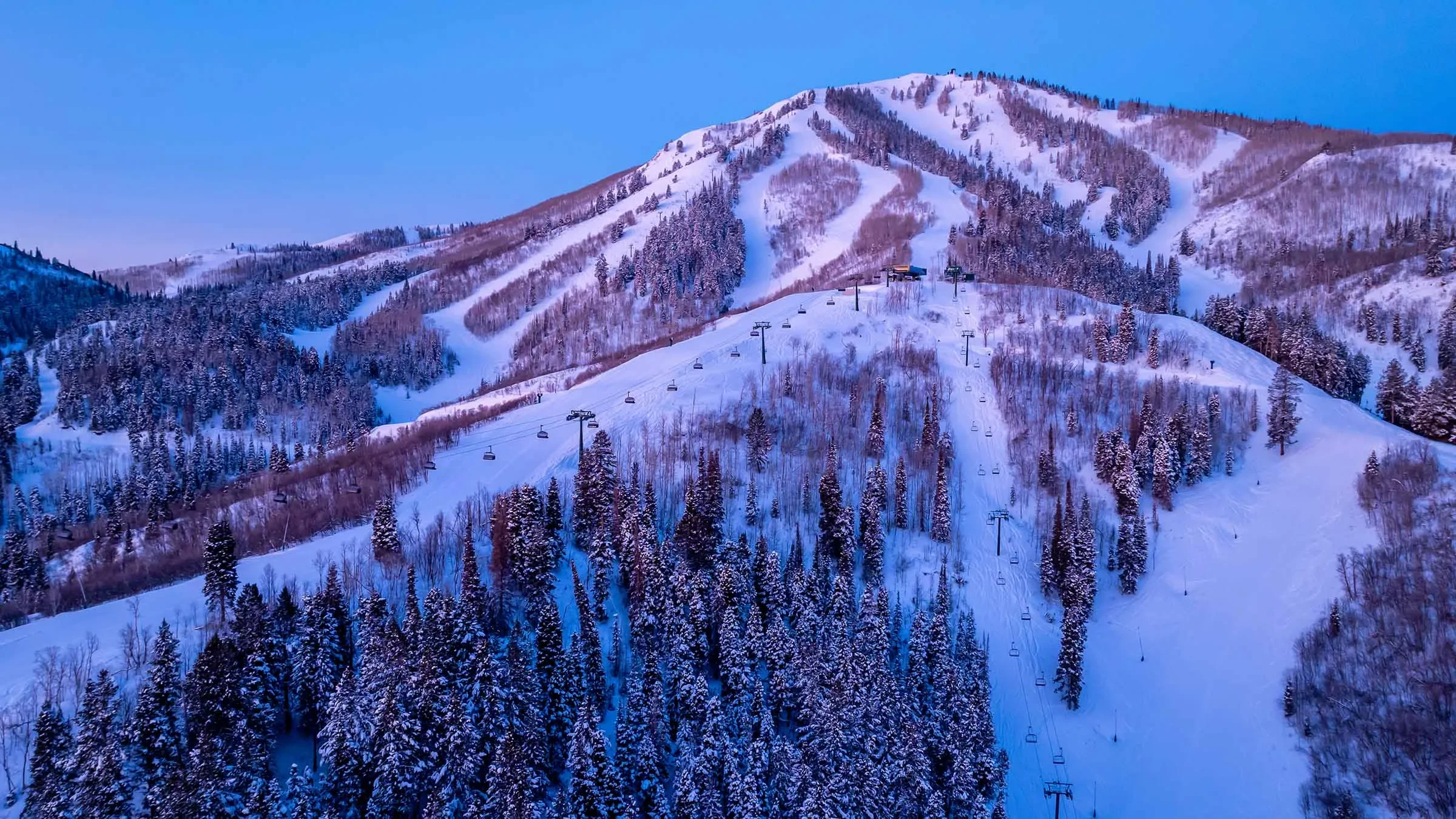Expanded Deer Valley ski terrain at twilight with mountain lifts and groomed runs