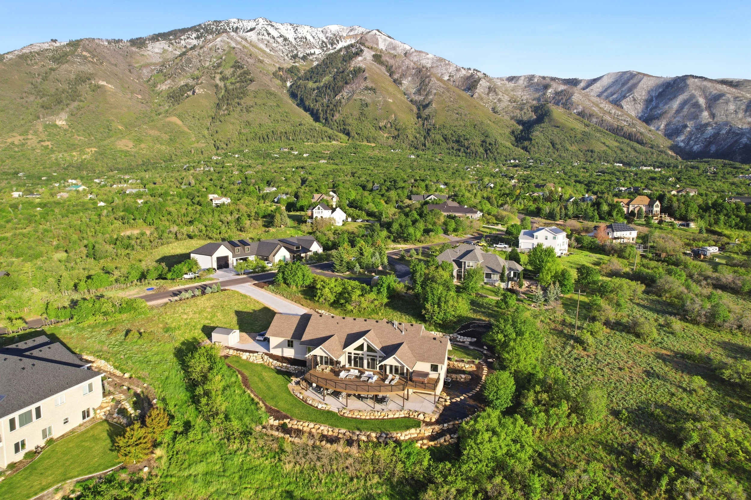 Aerial view of a Utah mountain community surrounded by green foothills and residential homes