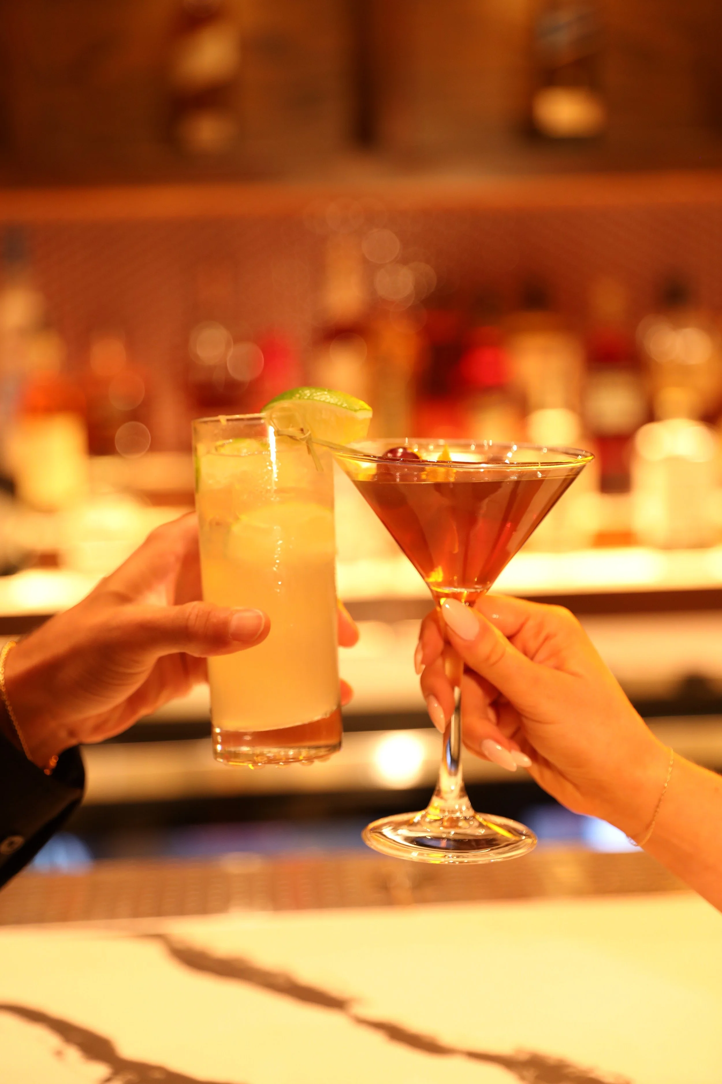 Two cocktails raised together at Penny’s Bar
