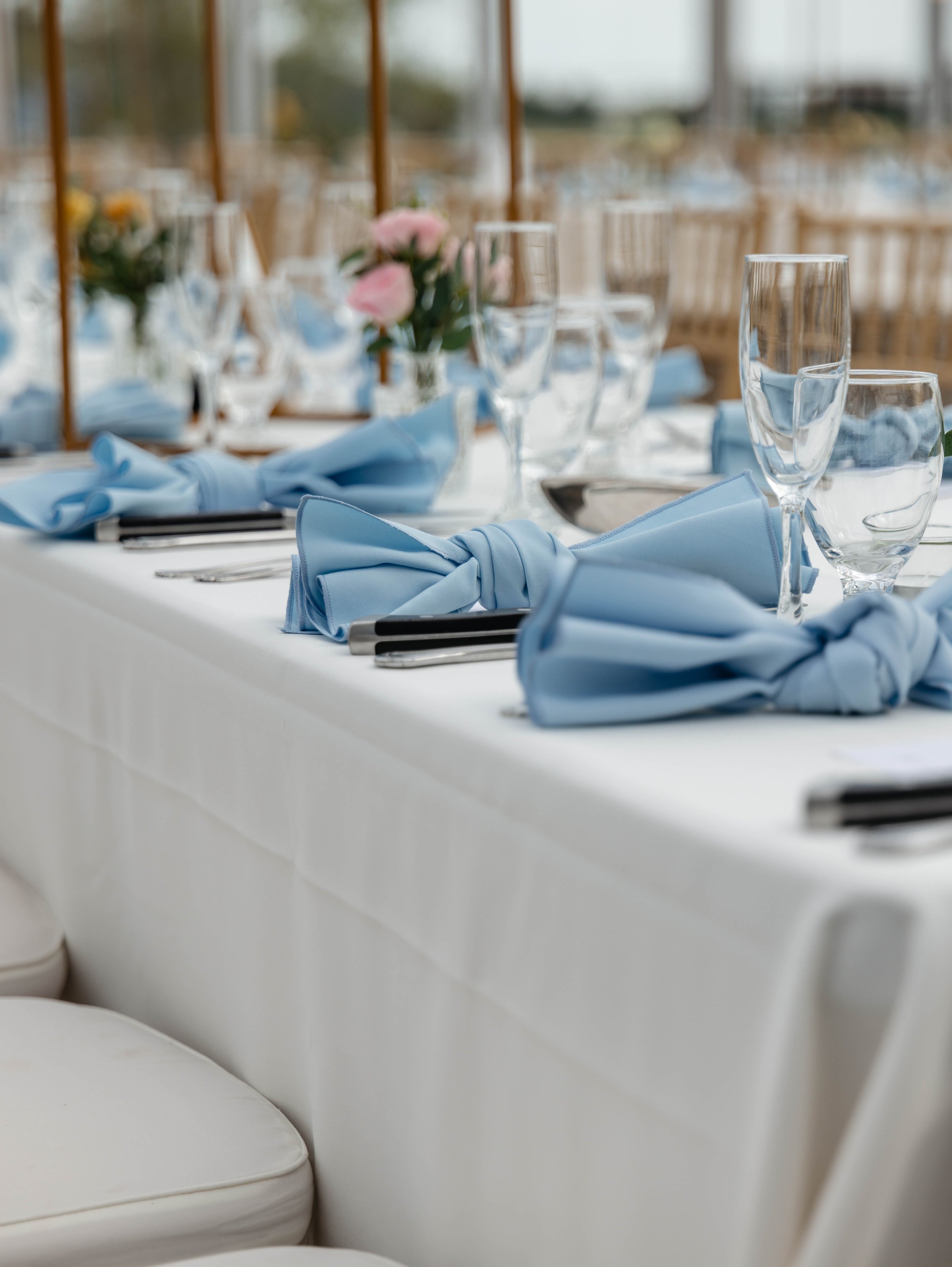 Blue wedding place settings arranged along a reception table