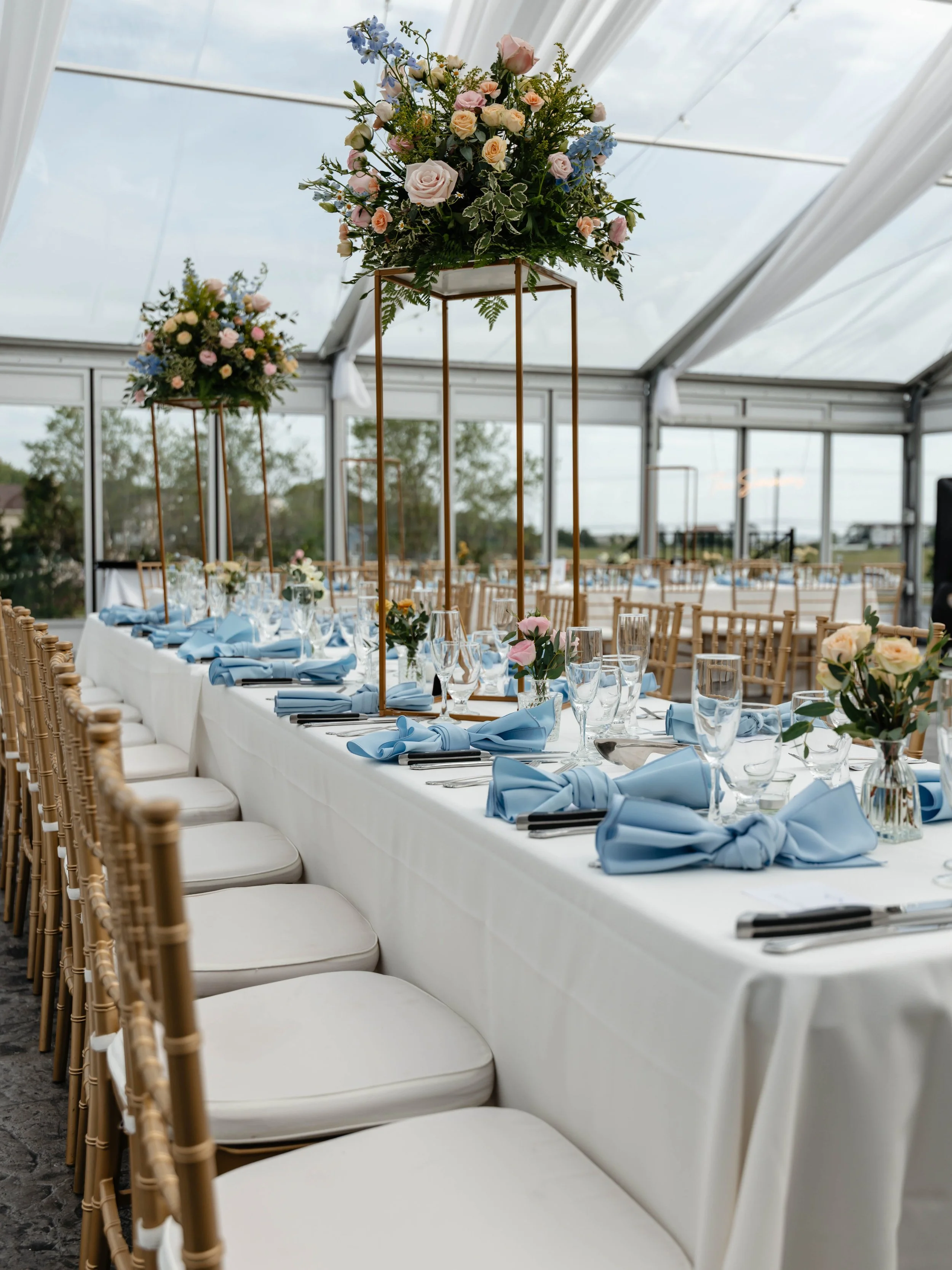 Elegant wedding tablescape beneath a light-filled tent