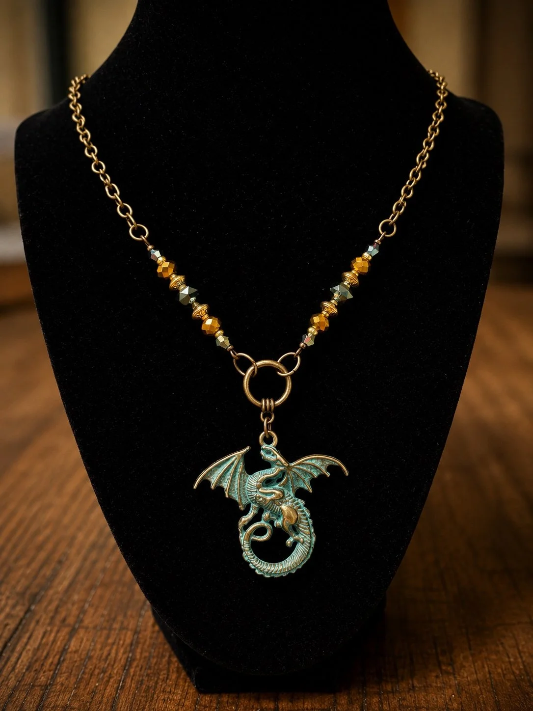 Handmade dragon pendant necklace displayed on a black jewelry bust.